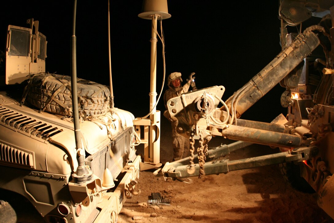 A motor transport Marine from Motor Transport Platoon, Headquarters and Service Company, 2nd Battalion, 25th Marine Regiment backs up a 7-ton wrecker to hitch it to a Humvee which broke down during a security patrol outside Al Asad Air Base Dec. 11, 2008.  The battalion completed their 7-month tour in Iraq in April 2009.
