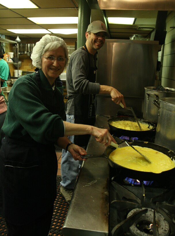 Brenda Edwards, a volunteer with the Foundry United Methodist church, cooks eggs for the So Others Might Eat food kitchen in Washington, Dec. 11. The volunteers worked with Marines, Sailors and civilians from Marine Barracks Washington to cook and serve more than 350 guests that morning, using more than 900 fresh eggs.