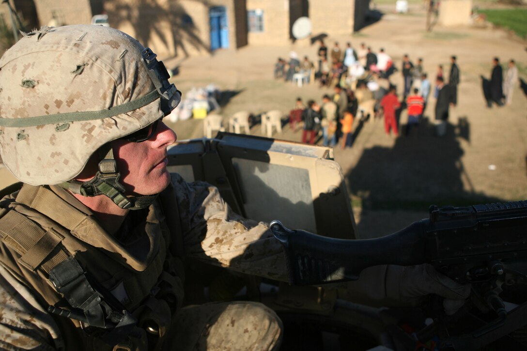 Lance Cpl. Nick E. Duffy, a rifleman with Company E, 2nd Battalion, 9th Marine Regiment, Regimental Combat Team 1, holds security during a meeting with the family of slain Iraqi Policeman Capt. Ali Rezaij, at the family’s home, Dec. 11. The Marines brought heaters, generators and blankets to help them through the winter.