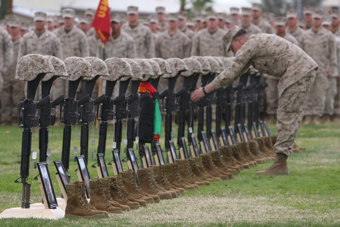 Memorials for 20 men who gave their lives during 2nd Battalion, 7th Marine Regiment's recent deployment to Afghanistan are perfectly aligned at 2/7’s memorial service Dec. 12 at the Combat Center’s Lance Cpl. Torrey L. Gray Field.  Fellow Marines hung dog tags over each service member’s rifle and tied a scarf with the colors of the Afghan flag around the buttstock of the Afghan interpreter’s memorial during the ceremonial role call.