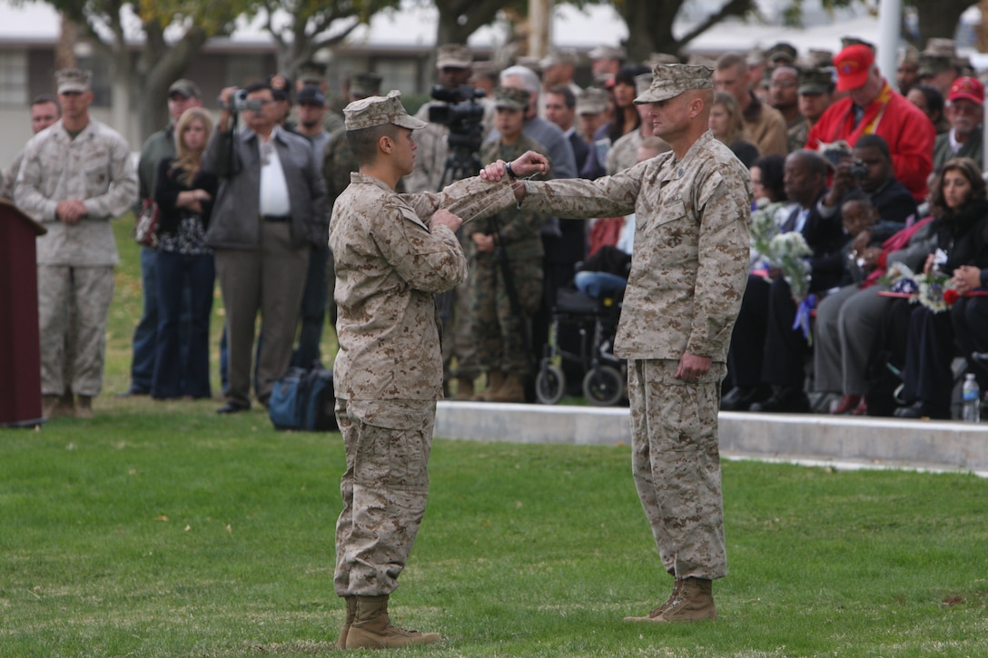 A Marine shows Sgt. Maj. Matthew Brookshire, the sergeant major of 2nd Battalion, 7th Marines, a dog tag of one of the fallen Marines during 2/7’s memorial service Dec. 12 at the Combat Center’s Lance Cpl. Torrey L. Gray Field.  The dog tag was draped over the Marines memorial as Brookshire called his name three times during a ceremonial role call.  Twenty men gave their lives during 2/7’s recent deployment to Afghanistan.