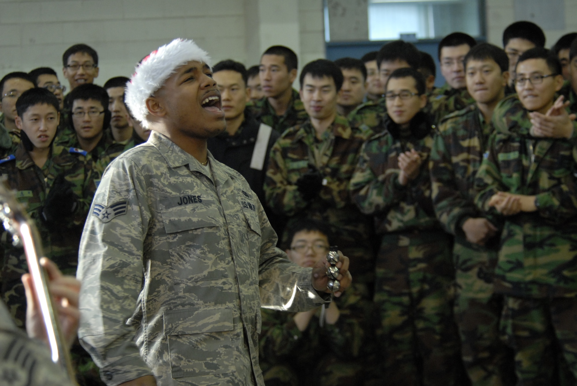 Senior Airman Andrew Jones, a member of the PACAF band, Pacific Trends, belts out a note while singing Christmas carols for the Republic of Korea Air Forces members at Kunsan Air Base, Republic of Korea, Dec. 12, 2008. Pacific Trends sang Christmas carols for the 8th Fighter Wing, the ROKAF, the employees at Gunsan City Hall and the members of the Korean National Police. (U.S. Air Force Photo by SSgt Jason Colbert)