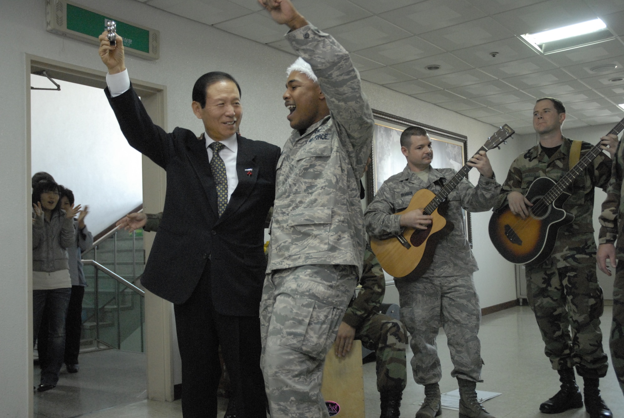 Senior Airman Andrew Jones, a member of the PACAF band, Pacific Trends and  Moon, Dong Shin, Mayor of Gunsan City, Republic of Korea, sing Christmas Carols at Gunsan City Hall, Dec. 11, 2008. Pacific Trends sang Christmas carols for the 8th Fighter Wing, the Republic of Korea Air Forces, the employees at Gunsan City Hall and the members of the Korean National Police. (U.S. Air Force Photo by SSgt Jason Colbert)