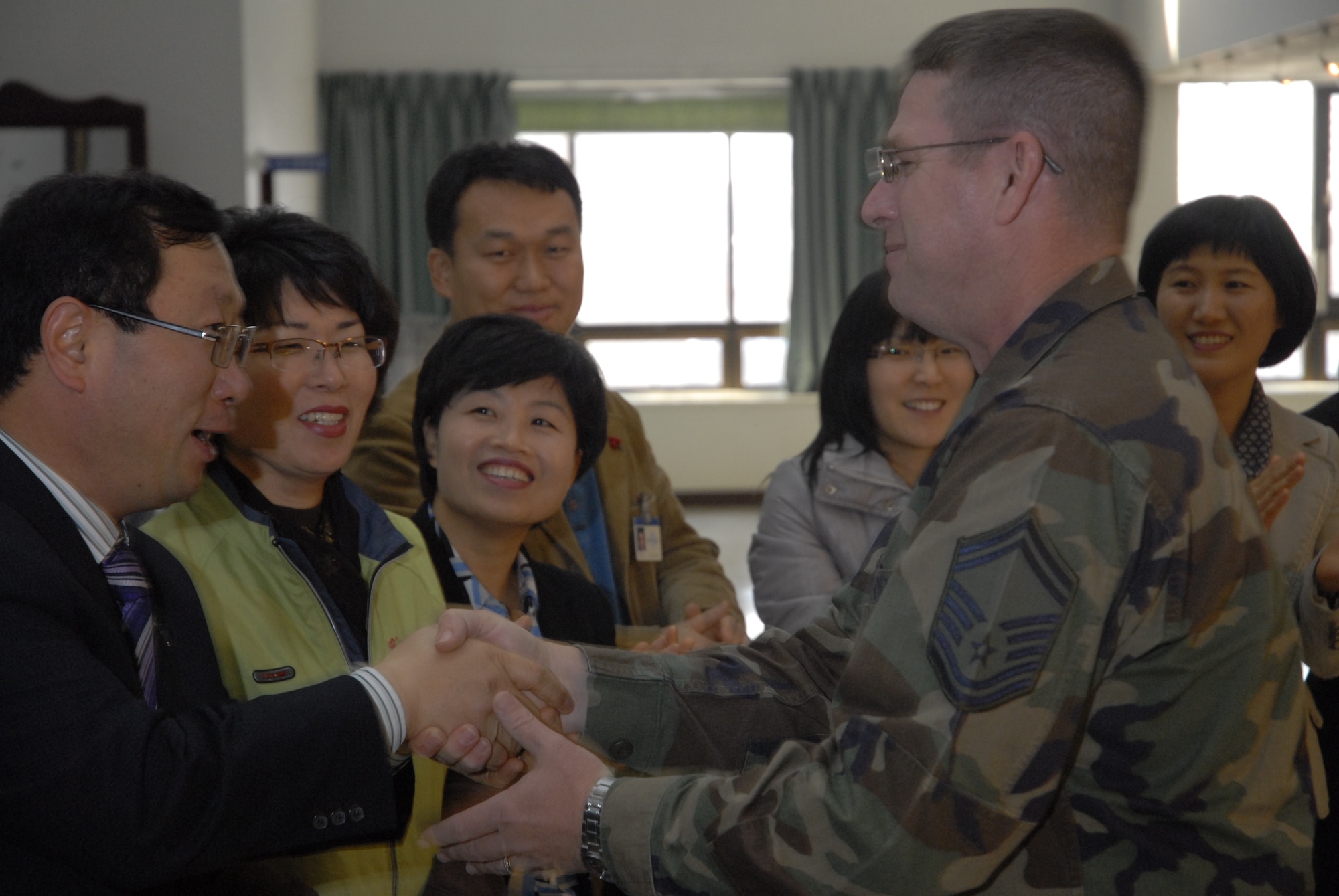 Senior Master Sgt. Daniel Smalley, a member of the PACAF band, Pacific Trends, shakes the hands of the crowd at Gunsan City Hall, Republic of Korea, Dec. 11, 2008. Pacific Trends sang Christmas carols for the 8th Fighter Wing, the Republic of Korea Air Forces, the employees at Gunsan City Hall and the members of the Korean National Police. (U.S. Air Force Photo by SSgt Jason Colbert)