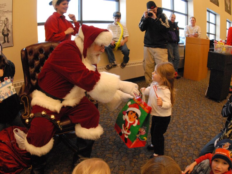 Elise, three-year old daughter of Master Sgt. Eric Johnson of the 119th Wing, receives a present in a ‘Dora the Explorer’ gift bag from Santa at the 119th Wing Children’s Christmas Party at the North Dakota Air National Guard on December 8, 2007.  
