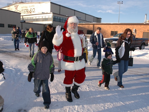 Santa walks with Happy Hooligan family members after arriving in C-21 Lear Jet for the annual 119th Wing Children’s Christmas Party at the North Dakota Air National Guard on December 8, 2007.