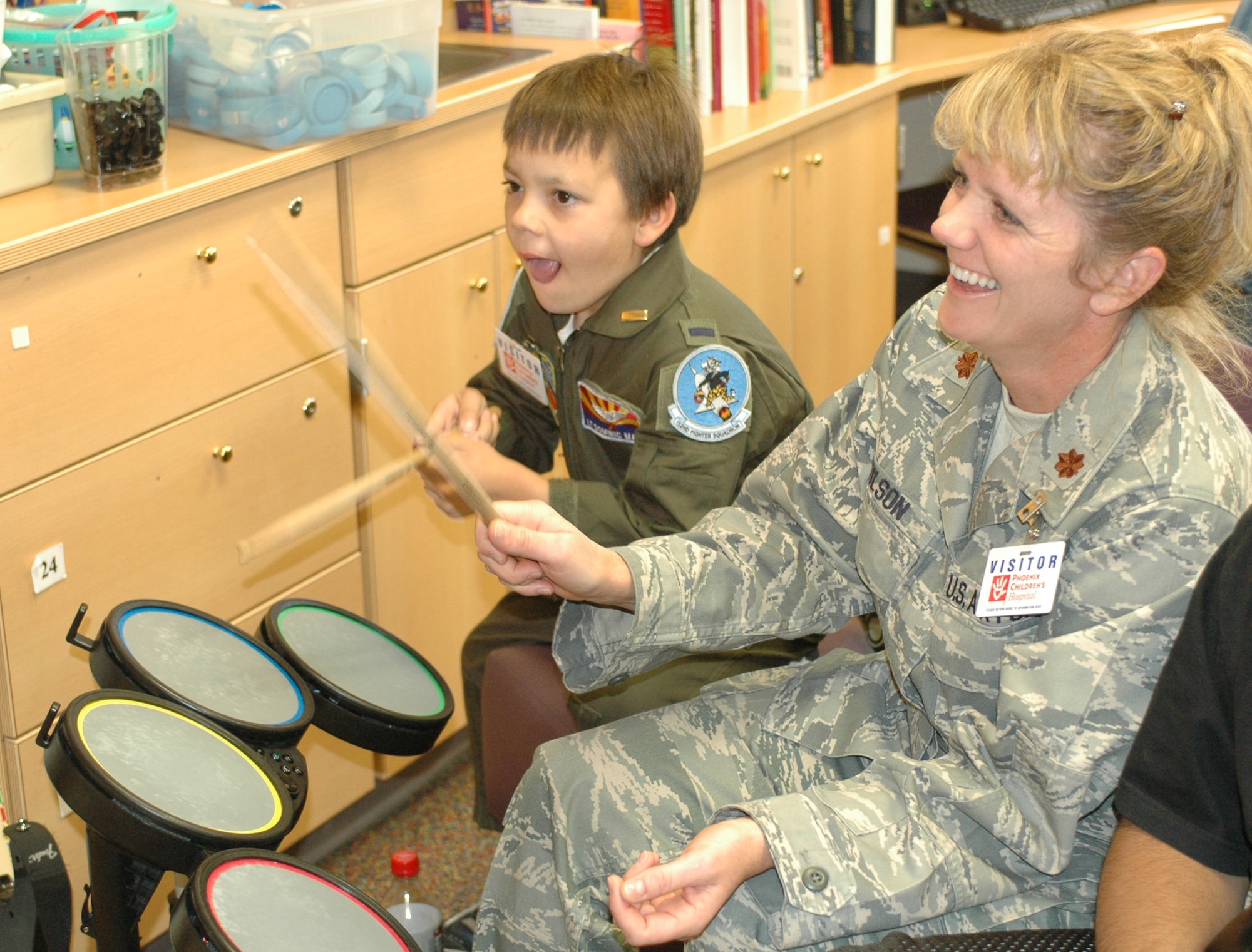 PHOENIX – Honorary 162nd Fighter Wing member Dominic Magne, 7, and Maj. Sandy Wilson play the video game “Rock Band” in a playroom at Phoenix Children’s Hospital. Wing members visited every floor and playroom in the hospital to ensure every child received a gift. The Tucson-based Guard unit held a gift drive in November and December resulting in more than 250 toys, games, books and DVDs. (Air National Guard photo by Capt. Gabe Johnson)