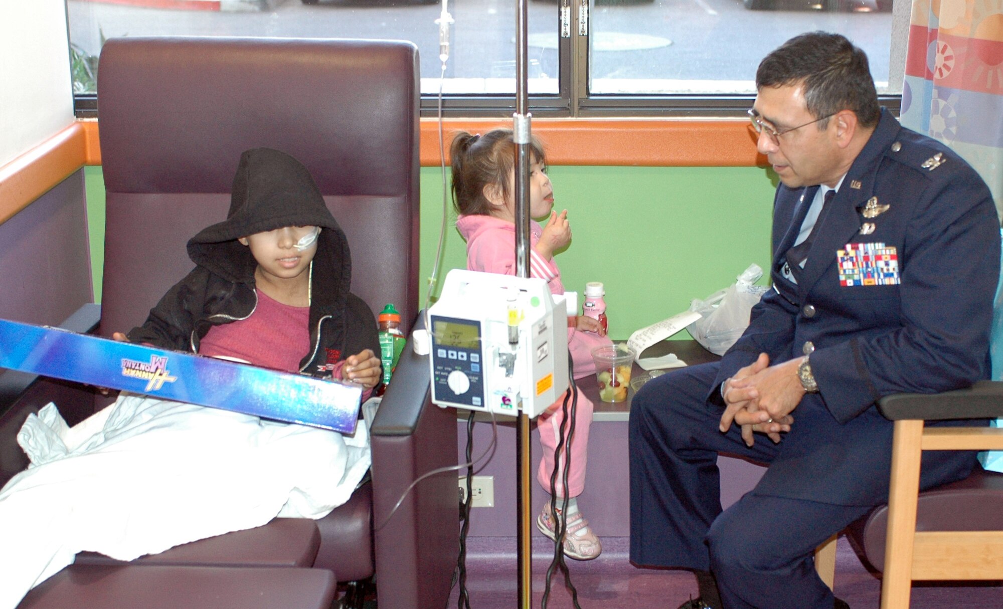 PHOENIX – Col. Jose Salinas, 162nd Fighter Wing Vice Commander, visits with Reyna Nebila, a young patient at Phoenix Children’s Hospital Dec. 11. The colonel and a handful of Arizona Air National Guardsmen made the trip to Phoenix to deliver toys, games, books and DVDs to the children. Reyna wanted anything to do with “Hanna Montana” and received a toy guitar themed after the hit TV series. (Air National Guard photo by Capt. Gabe Johnson)
