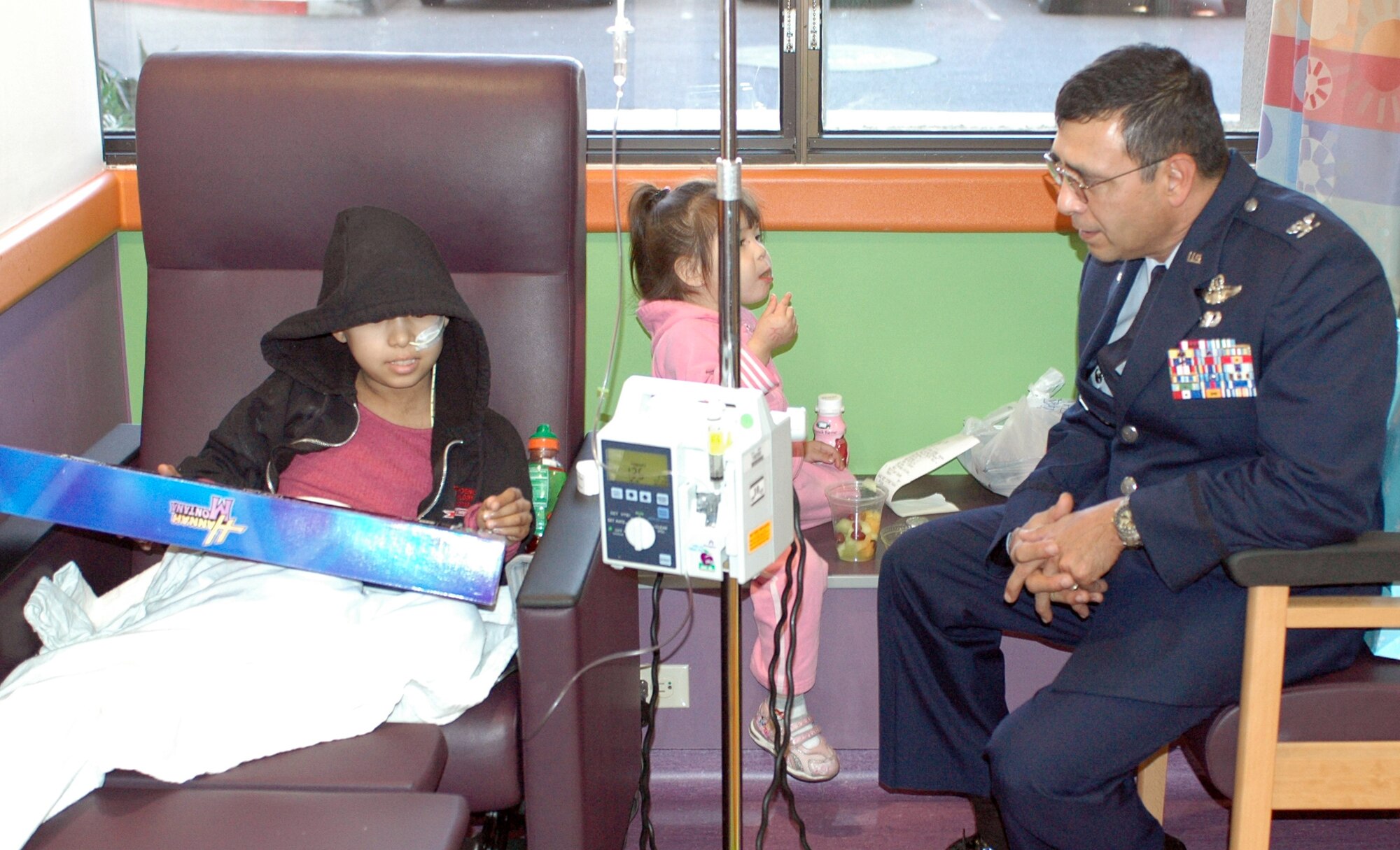 PHOENIX – Col. Jose Salinas, 162nd Fighter Wing Vice Commander, visits with Reyna Nebila, a young patient at Phoenix Children’s Hospital Dec. 11. The colonel and a handful of Arizona Air National Guardsmen made the trip to Phoenix to deliver toys, games, books and DVDs to the children. Reyna wanted anything to do with “Hanna Montana” and received a toy guitar themed after the hit TV series. (Air National Guard photo by Capt. Gabe Johnson)
