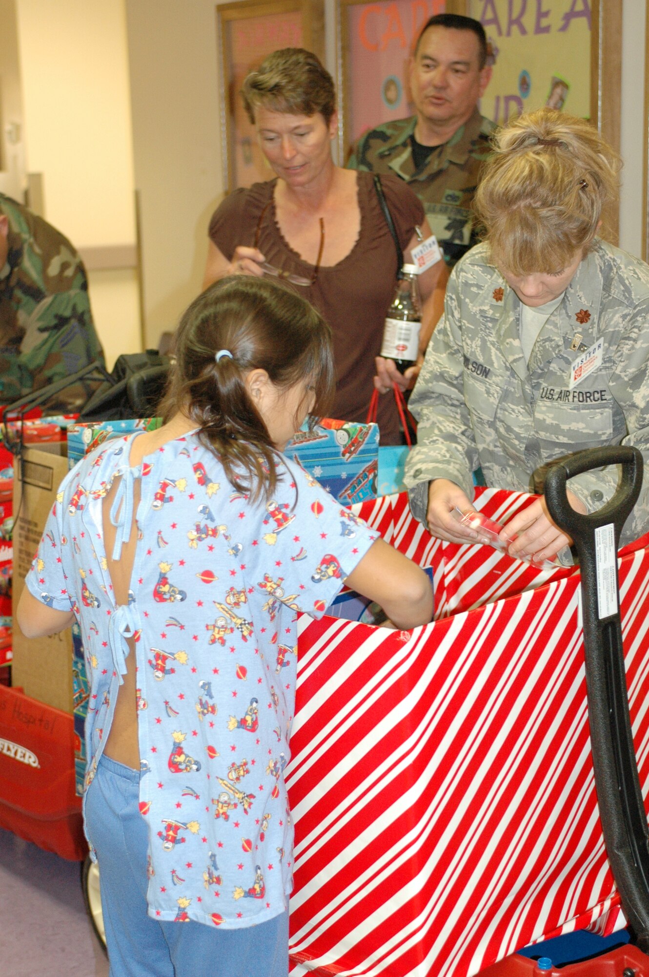 PHOENIX – Barb Gavre, Master Sgt. Dave Morgan and Maj. Sandy Wilson help a patient at Phoenix Children’s Hospital search for a gift from the 162nd Fighter Wing’s collection of donations Dec. 11. Wing members visited every floor and playroom in the hospital to ensure every child received a gift. The Tucson-based Guard unit held a gift drive in November and December resulting in more than 250 toys, games, books and DVDs. (Air National Guard photo by Capt. Gabe Johnson)