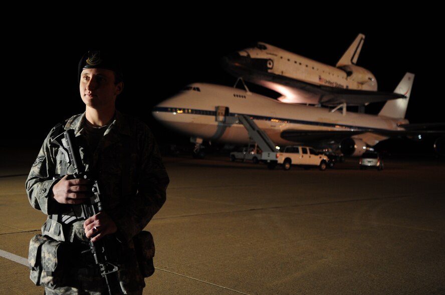 Senior Airman Andrew Perkins, 2d Security Forces Squadron, stands guard over Space Shuttle Endeavour. The shuttle sat atop a modified Boeing 747 carrier aircraft during a stop-over at Barksdale Air Force Base, La., during its transition from Edwards Air Force Base, Calif., to Cape Canaveral, Fla., Dec. 12. Shuttle Endeavour was diverted to Edwards AFB due to weather after a 16 day mission to make repairs and improvements on the International Space Station. (U.S. Air Force photo by Senior Airman Joanna M. Kresge)