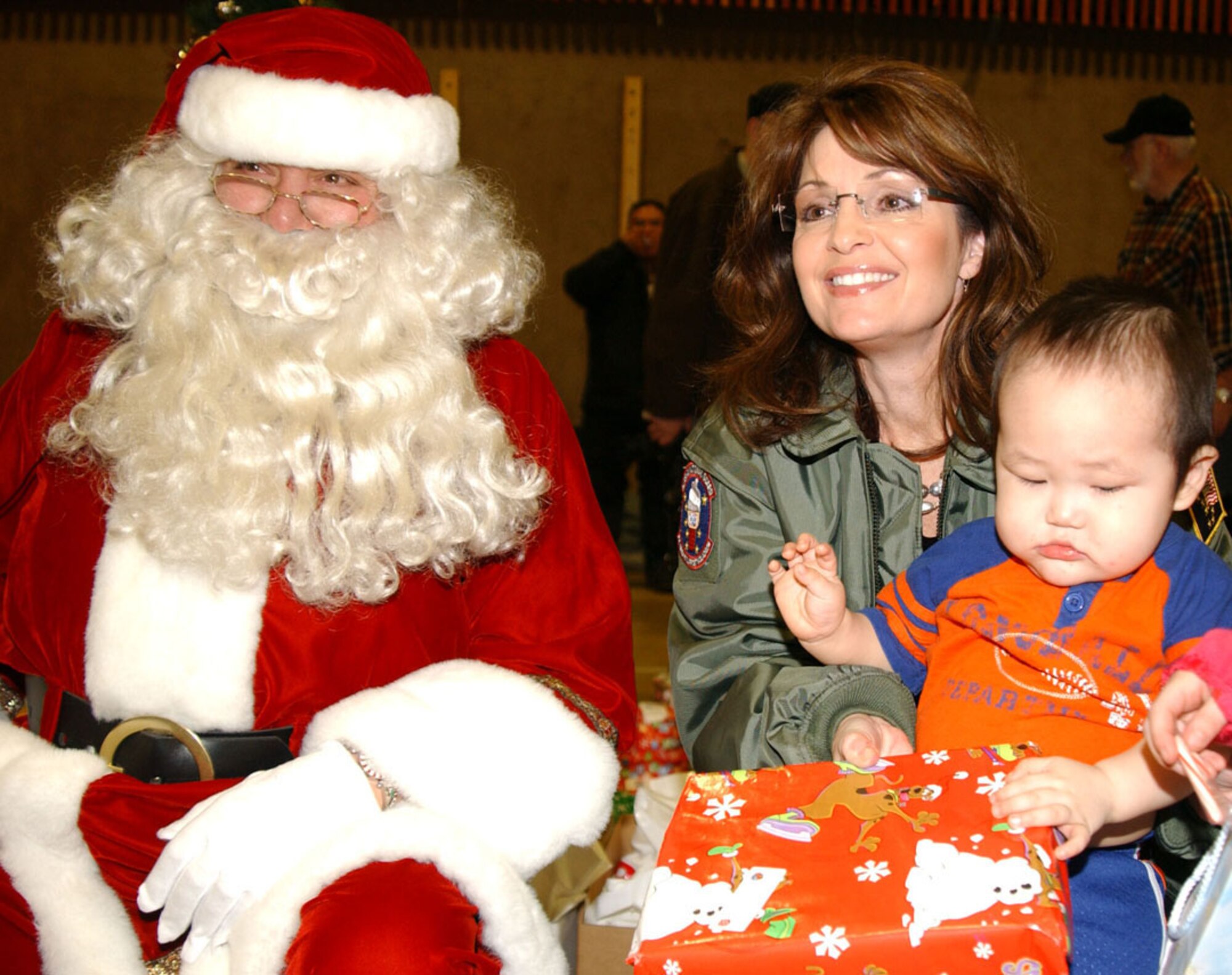 Alaska Gov. Sarah Palin helps Santa pass out gifts during Operation Santa Claus 2008 Dec. 6 in Kivalina, Alaska. Operation Santa Claus, an Alaska National Guard community relations and support program, provides toys, books and school supplies for young people in communities across the state. (U.S. Army photo/Spc. Paizley Ramsey)
