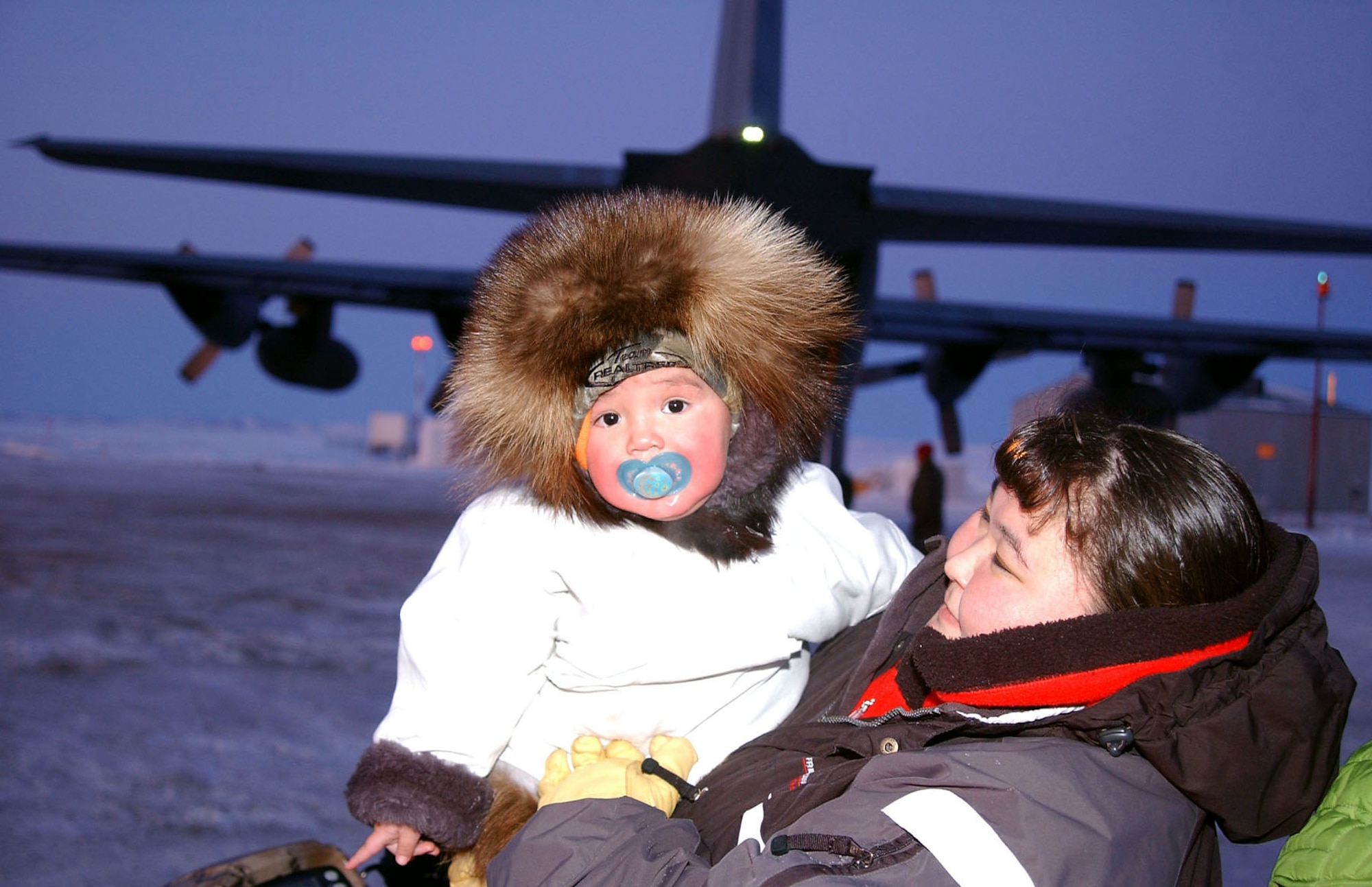 A mother and daughter help National Guard members load a C-130 Hercules at the end of a successful Operation Santa Claus visit Dec. 6 in Kivalina, Alaska. Operation Santa Claus, an Alaska National Guard community relations and support program, provides toys, books and school supplies for young people in communities across the state. (U.S. Army photo/Spc. Paizley Ramsey) 
