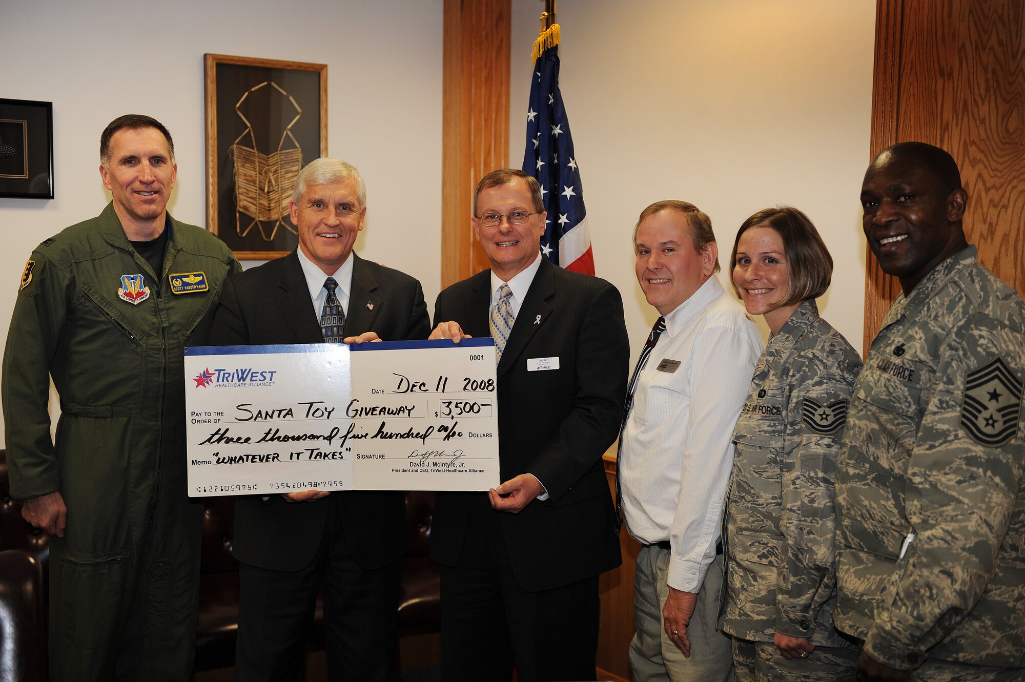 (Center) Don Brown and Tim Ray, TriWest representatives, present a check to Col. Scott Vander Hamm, 28th Bomb Wing commander, Airman and Family Readiness Center Representatives Mark Kjellerson and Tech. Sgt. Ann Mitchell, and Ellsworth Command Chief Master Sgt. Clifton Cole, for the Santa Toy Giveaway program here, Dec. 11. The Santa Toy Giveaway is conducted by the Airmen and Family Readiness Center and helps provide toys and items to families of deployed service members. (U.S. Air Force photo/Airman 1st Class Joshua J. Seybert)