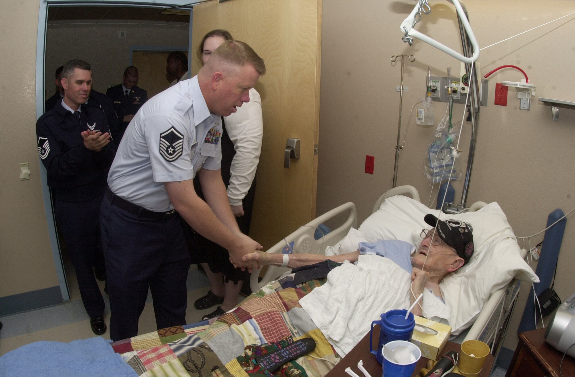 Master Sgt. Anthony Fleming, 17th Security Forces, introduces himsefl to 85-year-old Jimmy Burt, a World War II veteran, during a visit to patients at the Veterans Administration Medical Center in Big Spring, Texas.  Mr. Burt served in the Air Force at the time it was known as the Army Air Corps, and was assigned to the 559th Bomb Squadron under the 387th Bomb Group. He became a prisoner of war after the plane in which he was a crew member was shot down over Belgium. Five members of Mr. Burts crew lost their lives over Belgium. He retired as a warrant office first class. (U.S. Air Force photo by Senior Airman Luis Loza Gutierrez)