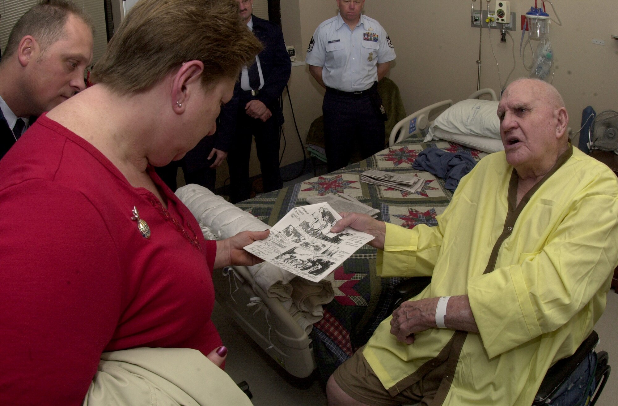 U.S. Marine Corps vetreran Lyndall Preslar shows Goodfellow Air Force Base visitors a copy of black and white photos taken of prisoners of war during World War II. Mr. Preslar was part of the group of POWs who took part in the infamous Bataan Death March in the Philippines in 1942. (U.S. Air Force photo by Senior Airman Luis Loza Gutierrez)