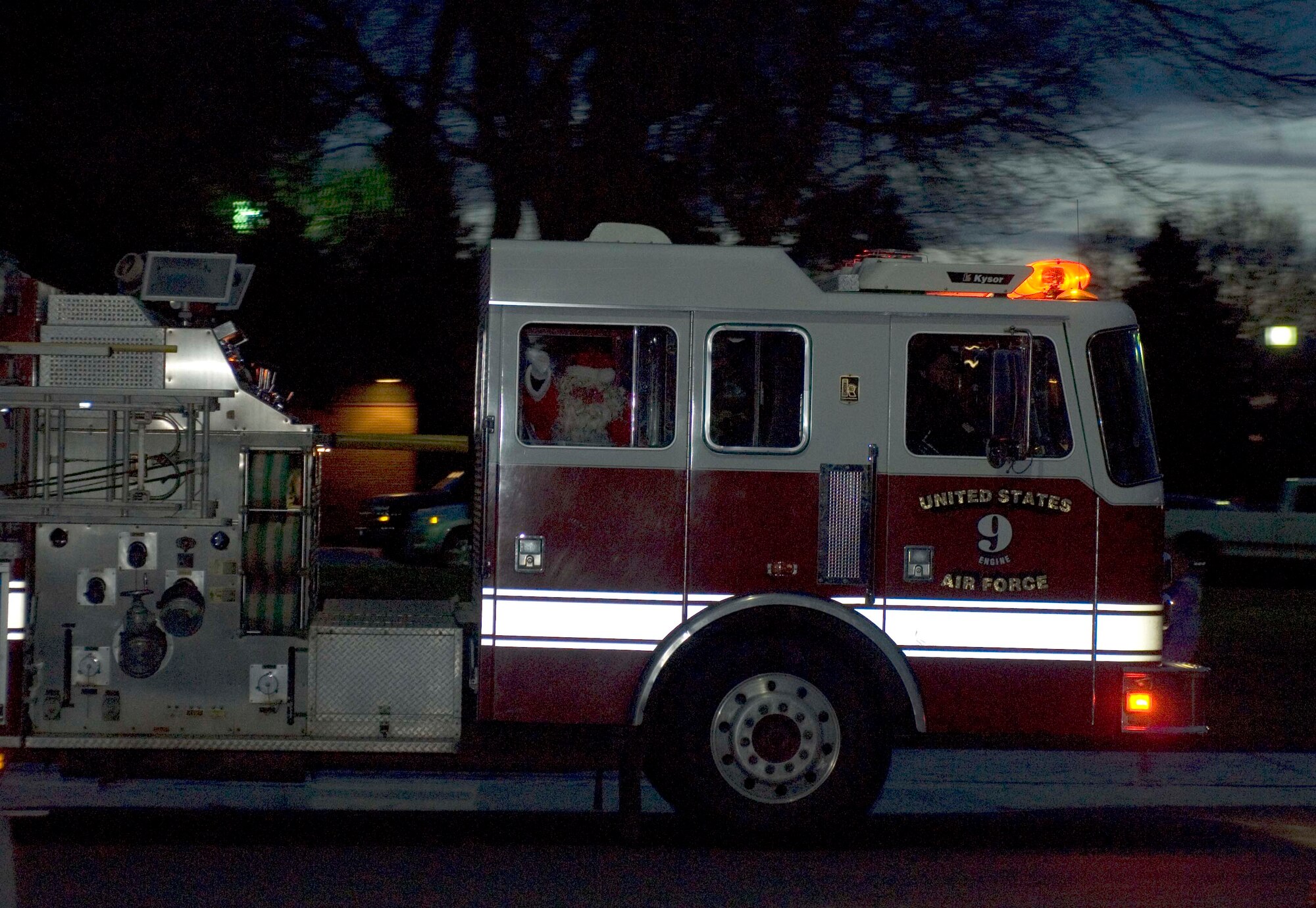 FAIRCHILD AIR FORCE BASE, Wash. – Santa Claus waves to spectators from a 92nd Civil Engineer Squadron fire engine along Poplar Avenue after the base Christmas-tree was lit Dec. 3. Children visited Santa at the chapel following the lighting. (U.S. Air Force photo / Airman 1st Class Darlene West)