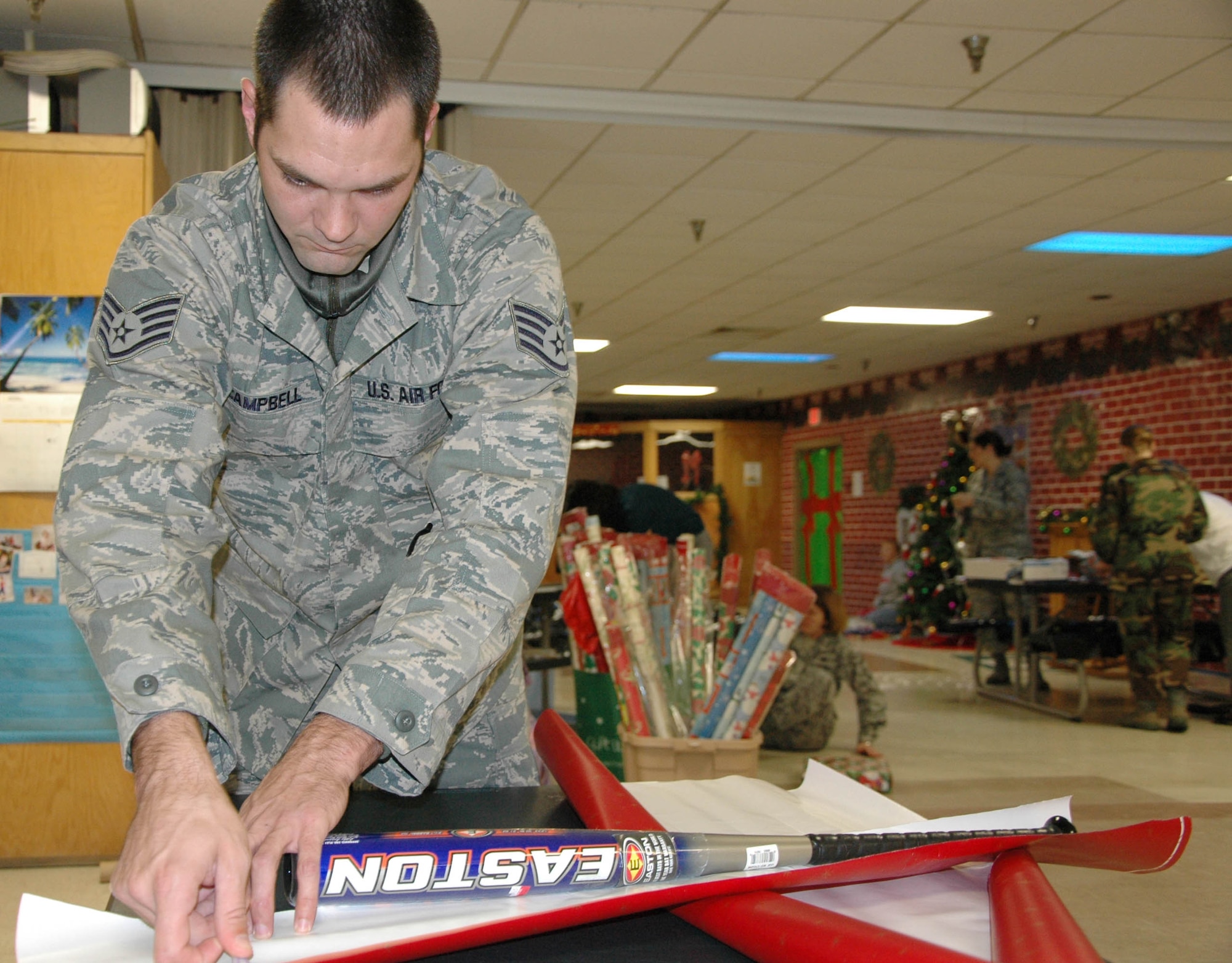 EGLIN AIR FORCE BASE, Fla. -- Staff Sgt. Brian Campbell, 96th Aerospace Medicinel Squadorn, wraps presents for the 28th Annual Give a Child a Christmas event. Children from low-income families and currently in foster care, protective custody or out-of-home situations the opportunity to experience a day filled with gifts and activities including games, lunch and a movie. (U.S. photo/ Staff Sgt. Stacia Zachary)