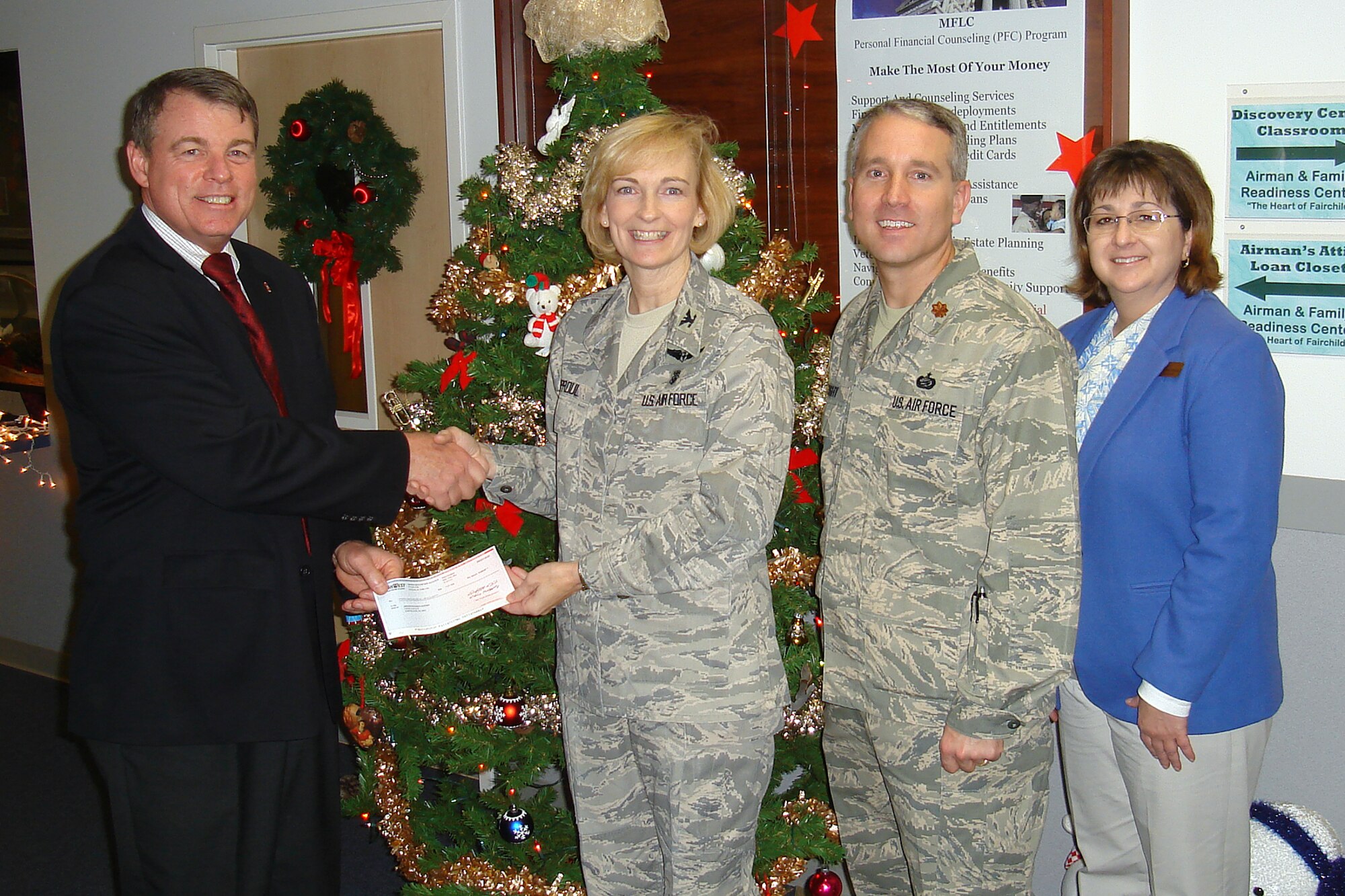FAIRCHILD AIR FORCE BASE, Wash. – TriWest Healthcare Alliance Service Area Director Mike Hanley presents a check for $5,000 to the 92nd Medical Group Commander, Col. Anne Sproul, accompanied by Maj. Jason Knight, the 92nd Force Support Squadron commander, and Maureen Hartford, the acting Director of the Airman & Family Readiness Center, at Fairchild Dec. 11. TriWest donated the funds in the spirit of the holiday season. (U.S. Air Force photo / Master Sgt. Scott Woller)
