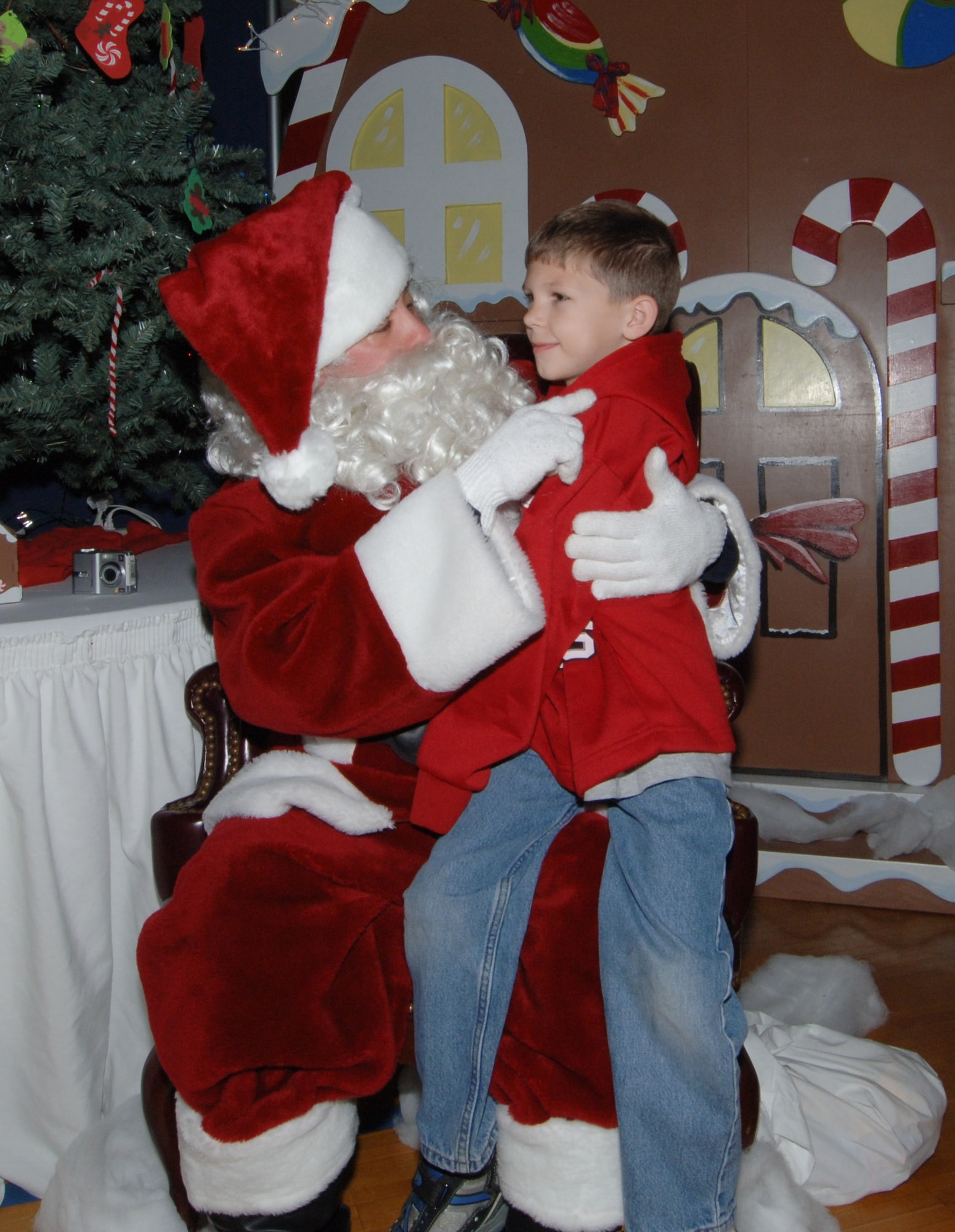 James Johnson, 7, son of Master Sgt. Saskia Johnson, Maxwell-Gunter Honor Guard superintendent, visits Santa to ask for a Nintendo DS for Christmas. Children of active duty, Reserve and Guard military members visited the Maxwell Youth Center on Saturday to have breakfast with Santa. More than 800 people attended the event which included cookie decorating, face painting, and goodie bag decorating. At least two local businesses provided free goodies to the attendees. (Air Force photo by Melanie Rodgers)