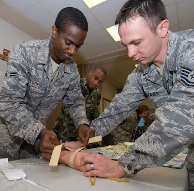 Combat Lifesaver Course instructor, Tech. Sgt. Brad Evans, talks Airman 1st Class Gary Cooper, 42nd Logistics Readiness Flight, through venipunture Dec. 4. The CLS course is accomplished by Airmen prior to a deployment. (Air Force photo by Jamie Pitcher)