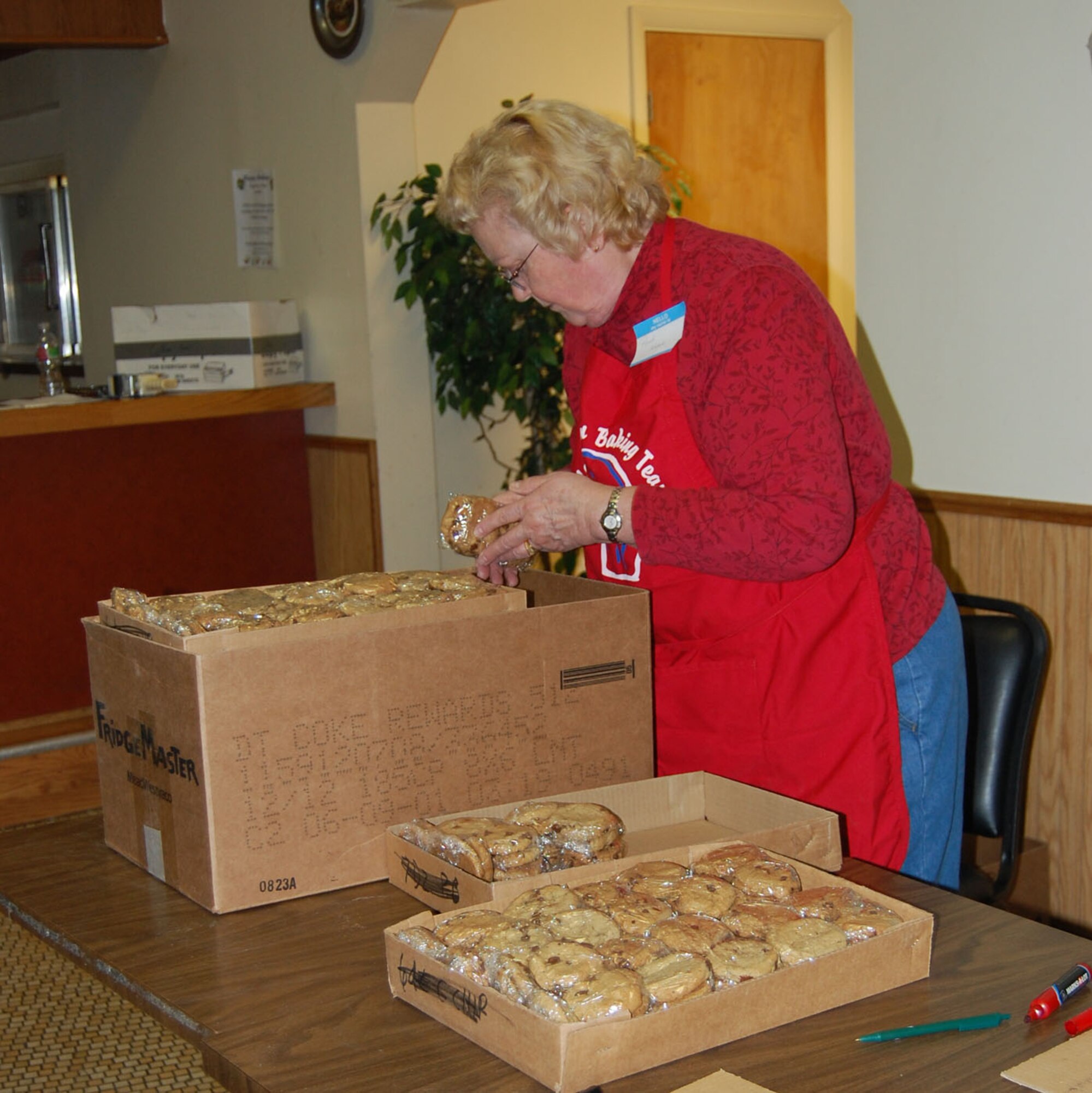 Penny Kubick gets the packaged chocolate chip cookies ready to be sent to the Dining Facility freezer where they were stored until Dec. 6 when the boxes were assembled for shipping to deployed Montana military members. (U.S. Air Force photo/Valerie Mullett)