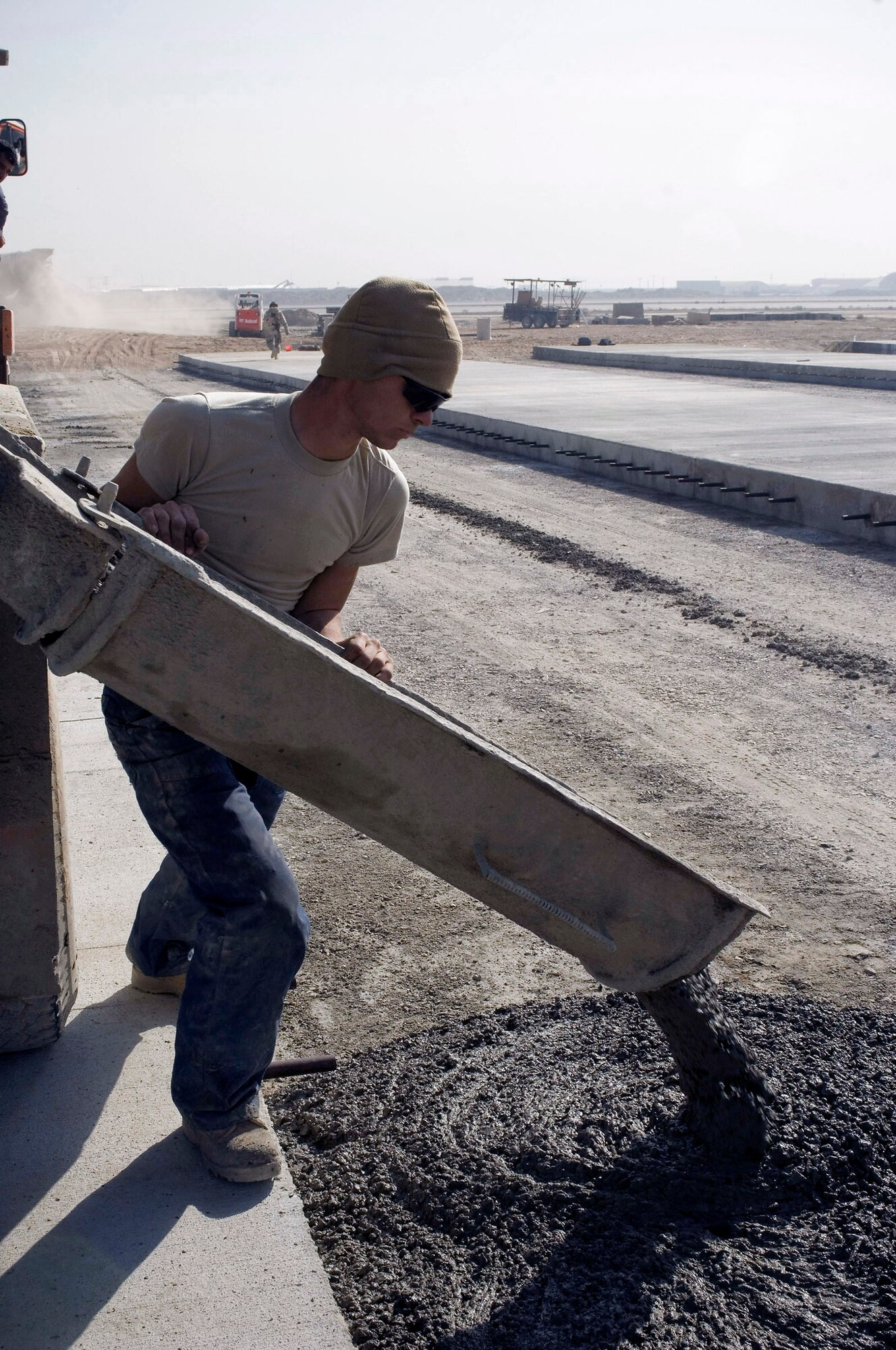 Airman 1st Class Christopher Gaudette pours concrete from a truck on the flightline Nov. 25 at Bagram Airfield, Afghanistan. Since August, members of the 455th ECES poured more than 2,075 cubic meters of concrete as part of construction projects designed to expand the airfield. Airman Gaudette is assigned to the a 455th Expeditionary Civil Engineer Squadron and deployed from Pope Air Force Base, N.C. (U.S. Air Force photo/Staff Sgt. Rachel Martinez)