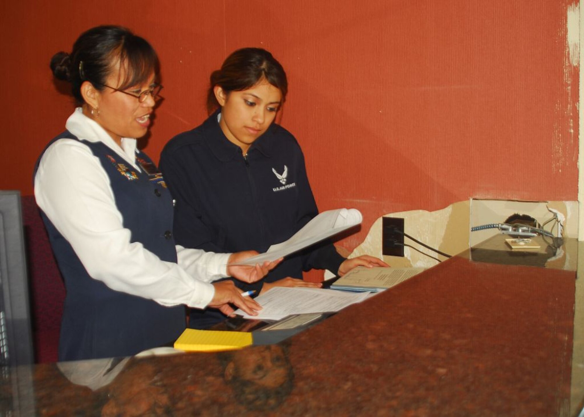 ALTUS AIR FORCE BASE, Okla. -- Maria Miller and Airman 1st Class Minerva Gonzalez of the 97 FSS Red River Inn work behind a desk under renovation. With a grant provided by the Air Force Lodging Fund, The Red River Inn facility renovations include the addition of The Back Door Country Store, a sundries shop slated to be completed in the first quarter of 2009 and several cosmetic improvements.  (U.S. Air Force photo/Senior Airman Amanda M. Bower)