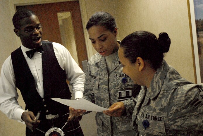 Tech Sgt. Joshua Gates gets assistance from Airmen 1st Class Jasmine Frazier and Cierra Thurman in leading holiday carols at the base clinic Dec. 10. The Air Combat Command band performed for Airmen, family members, civilian employees and retirees around the base blending traditional music of Ireland, Scotland, and England with a contemporary musical style creating a stunning musical tapestry. Sergeant Gates is a member of the Heritage Aire Celtic Ensemble from Langley AFB, VA. and Airmen Frazier and Thurman are from the 437th Medical Group. (U.S. Air Force photo/Tech. Sgt. David Watson) 
