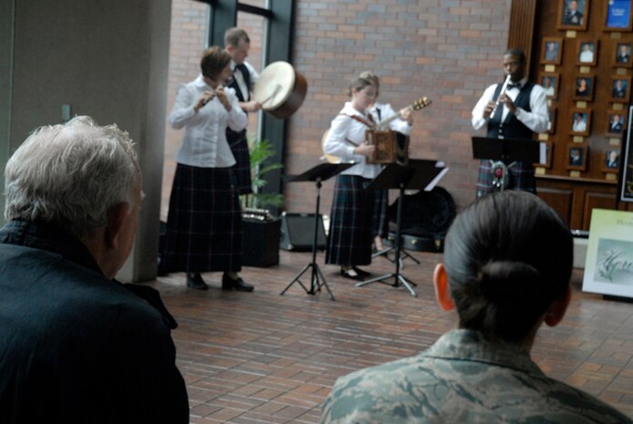 Bobby Pierce and Staff Sgt. Dina Maldonado listen to the holiday caroling sounds of the Heritage Aire Celtic Ensemble, Langley AFB, VA. at the wing headquarters building Dec. 10. The Air Combat Command band performed for Airmen, family members, civilian employees and retirees around the base by blending traditional music of Ireland, Scotland and England with a contemporary musical style creating a stunning musical tapestry. Sergeant Maldonado is assigned to the 437th Airlift Wing and Mr. Pierce is a member of the 437th Operation Support Squadron. (U.S. Air Force photo/Tech. Sgt. David Watson)