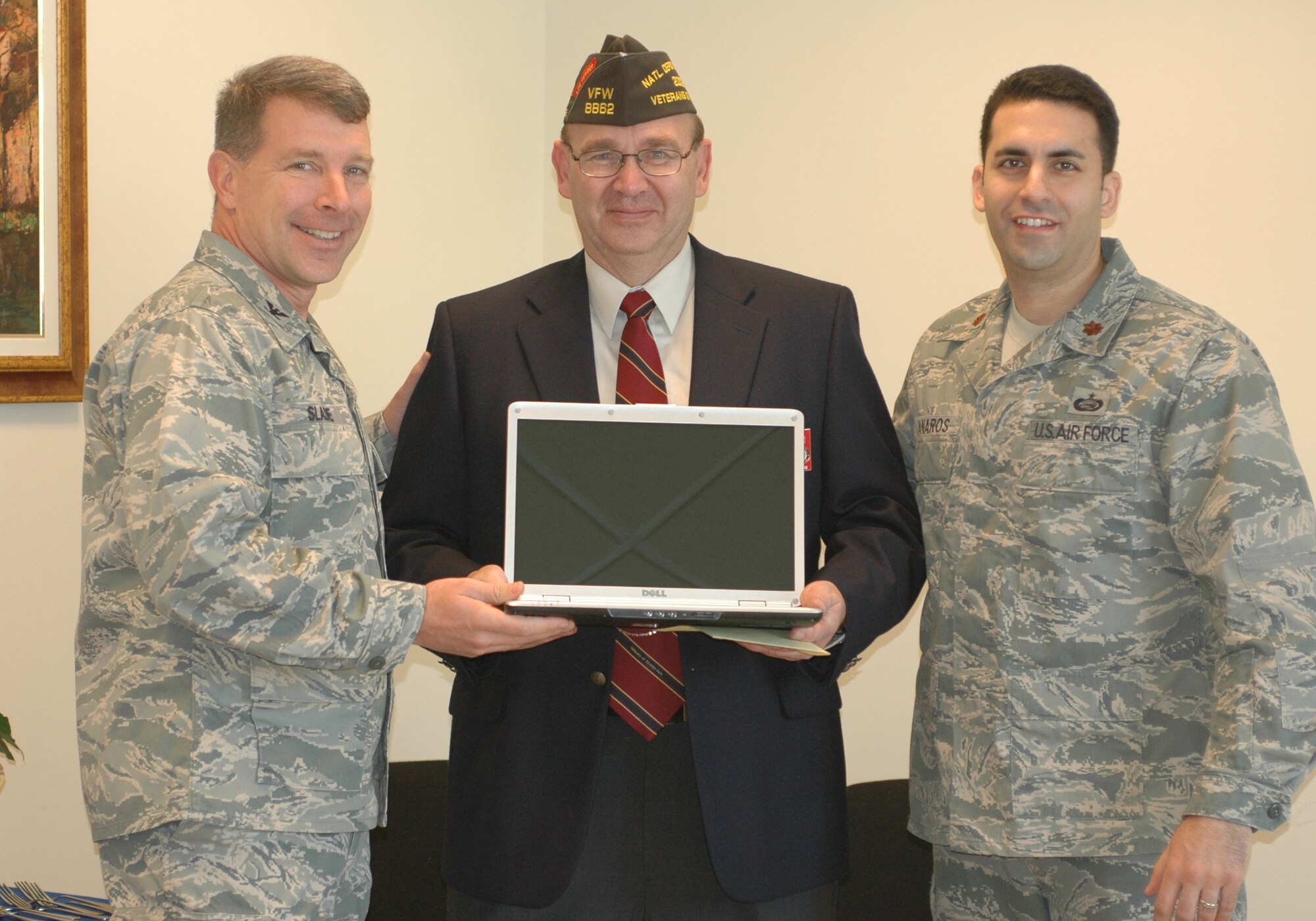 Tom Buffington, VFW Department of Europe senior vice commander, presents one of 12 laptop computers, to Col. David Slade, 31st Mission Group commander, and Maj. Jason Janaros, 31st Force Support Squadron commander, during a ceremony on Dec. 9 at the Aviano Airman and Family Readiness Center. The VFW donated the laptops to the center for use with its training programs and to supplement those consoles in its computer lab. (U.S. Air Force photo/Staff Sgt. Lindsey Maurice)
