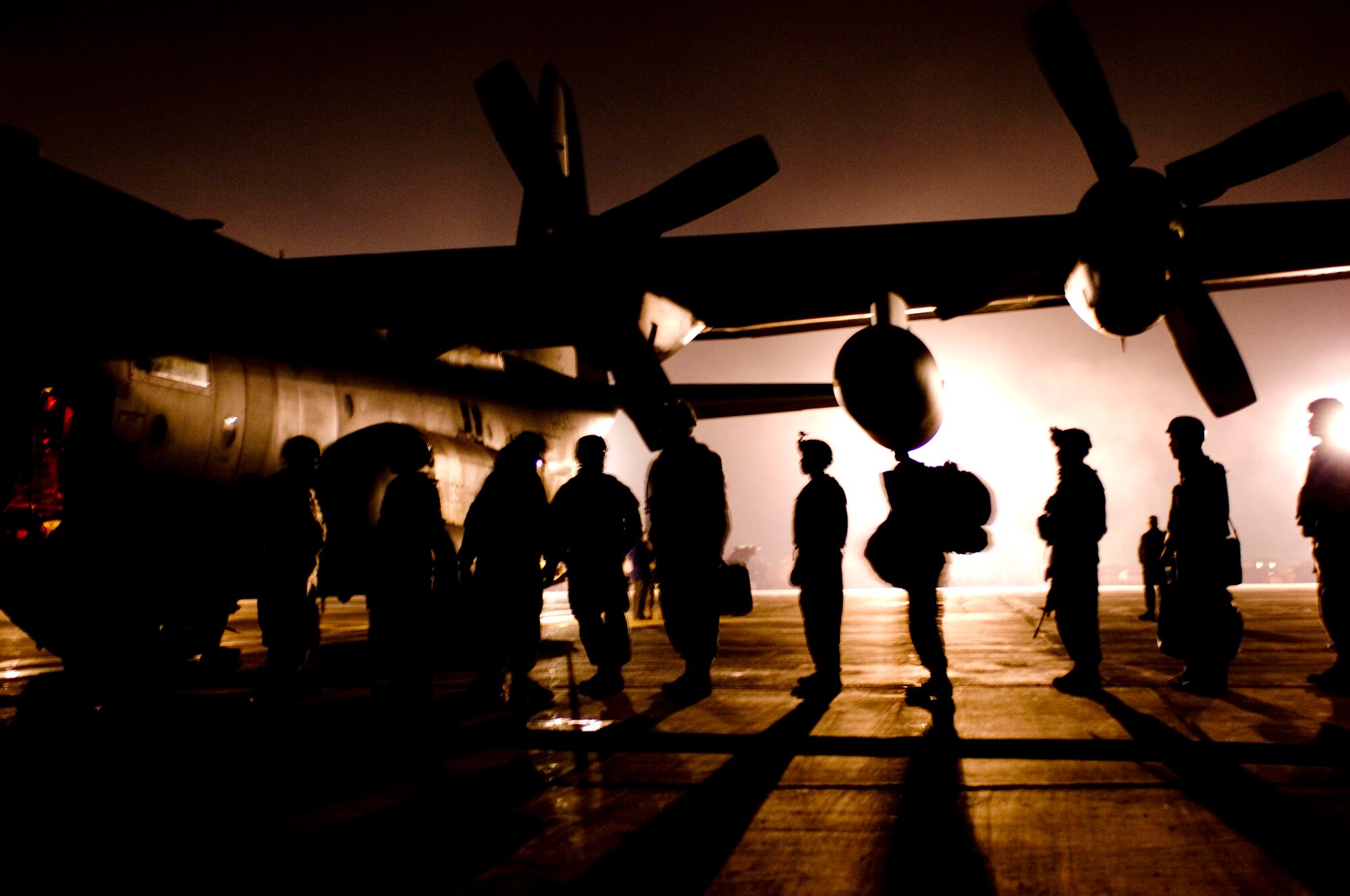 A group of U.S. Army Soldiers line up to board a C-130H Hercules at Bagram Air Field, Afghanistan, Nov. 30. The C-130 is used to transport troops through the mountainous terrain and is able to land on the dirt air strips found at many of the bases throughout Afghanistan. (U.S. Air Force photo by Staff Sgt. Rachel Martinez) (Released)