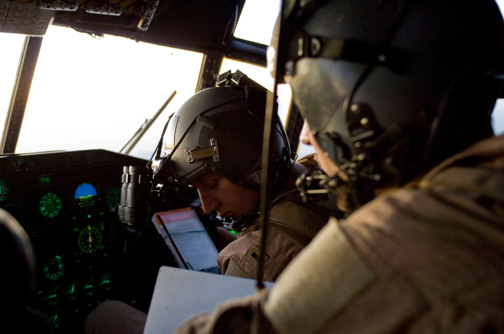 Tech. Sgt. Joel Sainsbury (right), a C-130 Hercules flight engineer, and 1st Lt. Jason Christensen, a C-130 pilot, review data during a flight over Afghanistan Dec. 1. The C-130 has been performing tactical airlift for nearly five decades, and is a key element to moving cargo and troops throughout Afghanistan. Sergeant Sainsbury and Lieutenant Christensen are assigned to the 774th Expeditionary Airlift Squadron and deployed from the Minnesota Air National Guard. (U.S. Air Force photo by Staff Sgt. Rachel Martinez) (Released)