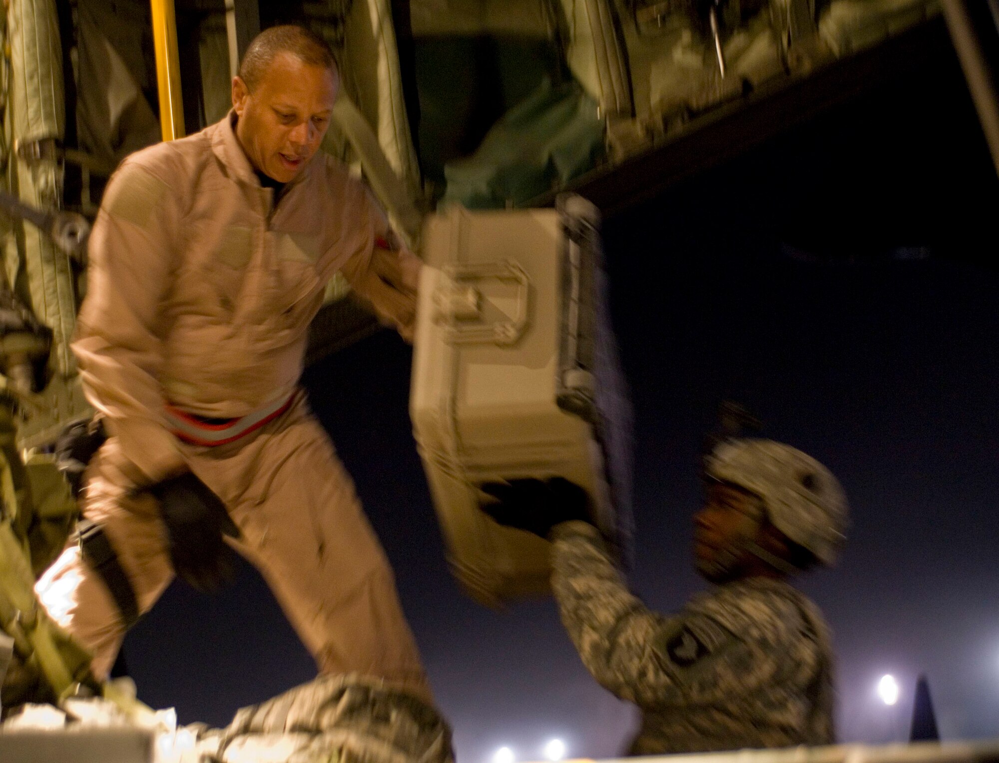 Chief Master Sgt. Byron Todd, a loadmaster with the 774th Expeditionary Airlift Squadron, grabs cargo from a U.S. Army Soldier to be tied down in the back of a C-130H Hercules at Bagram Air Field, Afghanistan, Nov. 30. The C-130 is the primary aircraft used to move cargo and passengers around Afghanistan. Chief Todd is deployed from the Minnesota Air National Guard. (U.S. Air Force photo by Staff Sgt. Rachel Martinez) (Released)