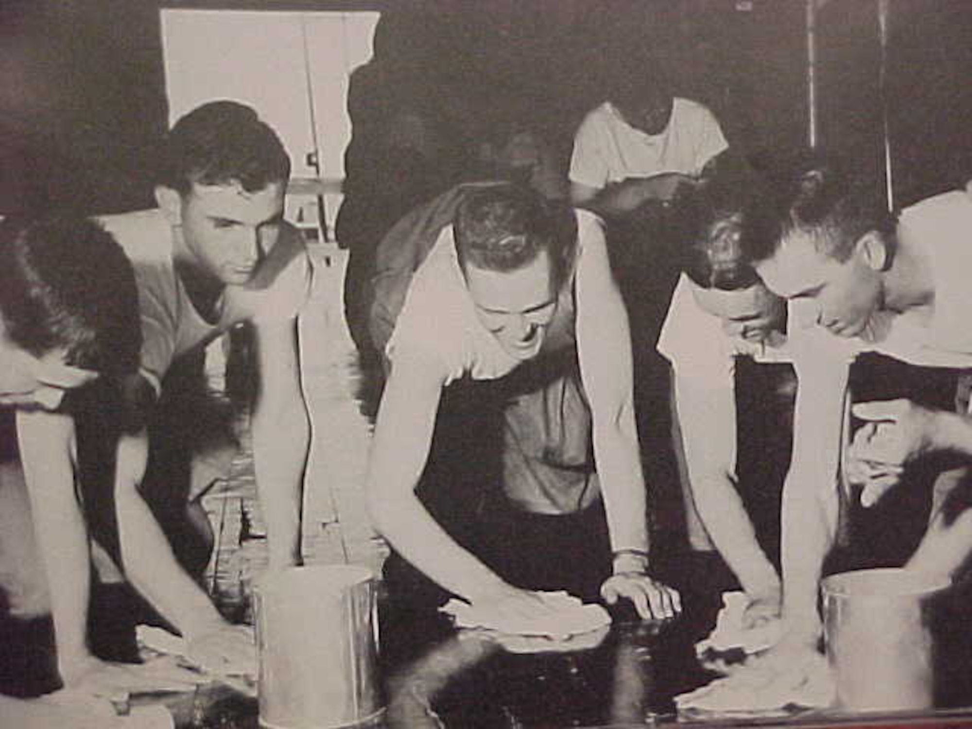 a vintage photo of airmen diligently cleaning floors