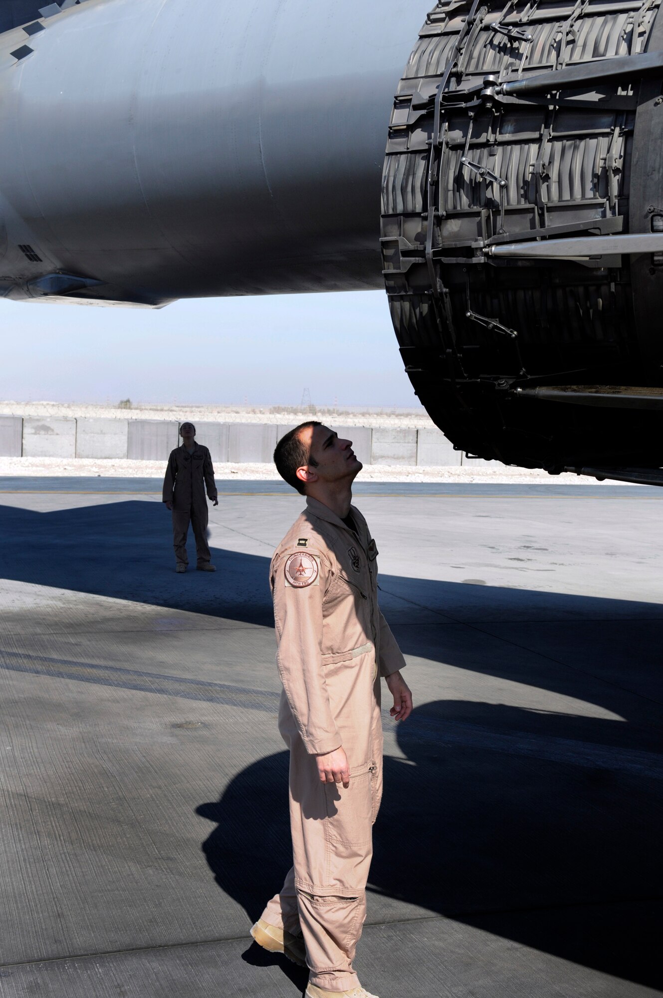 Capt. Aaron Wargo, a pilot assigned to the 34th Expeditionary Bomb Squadron, checks out a B-1 engine, while Capt. Daniela Lozano, a weapons system officer also assigned to the 34 EBS, looks over the tail section during a pre-flight walk around of the aircraft at an undisclosed air base in Southwest Asia. Captain Wargo is a native of Garden Grove, Calif., and   Captain Lozano hails from Dallas, Texas. Both are deployed from Ellsworth Air Force Base, S.D. (U.S. Air Force photo by Tech. Sgt. Michael Boquette)