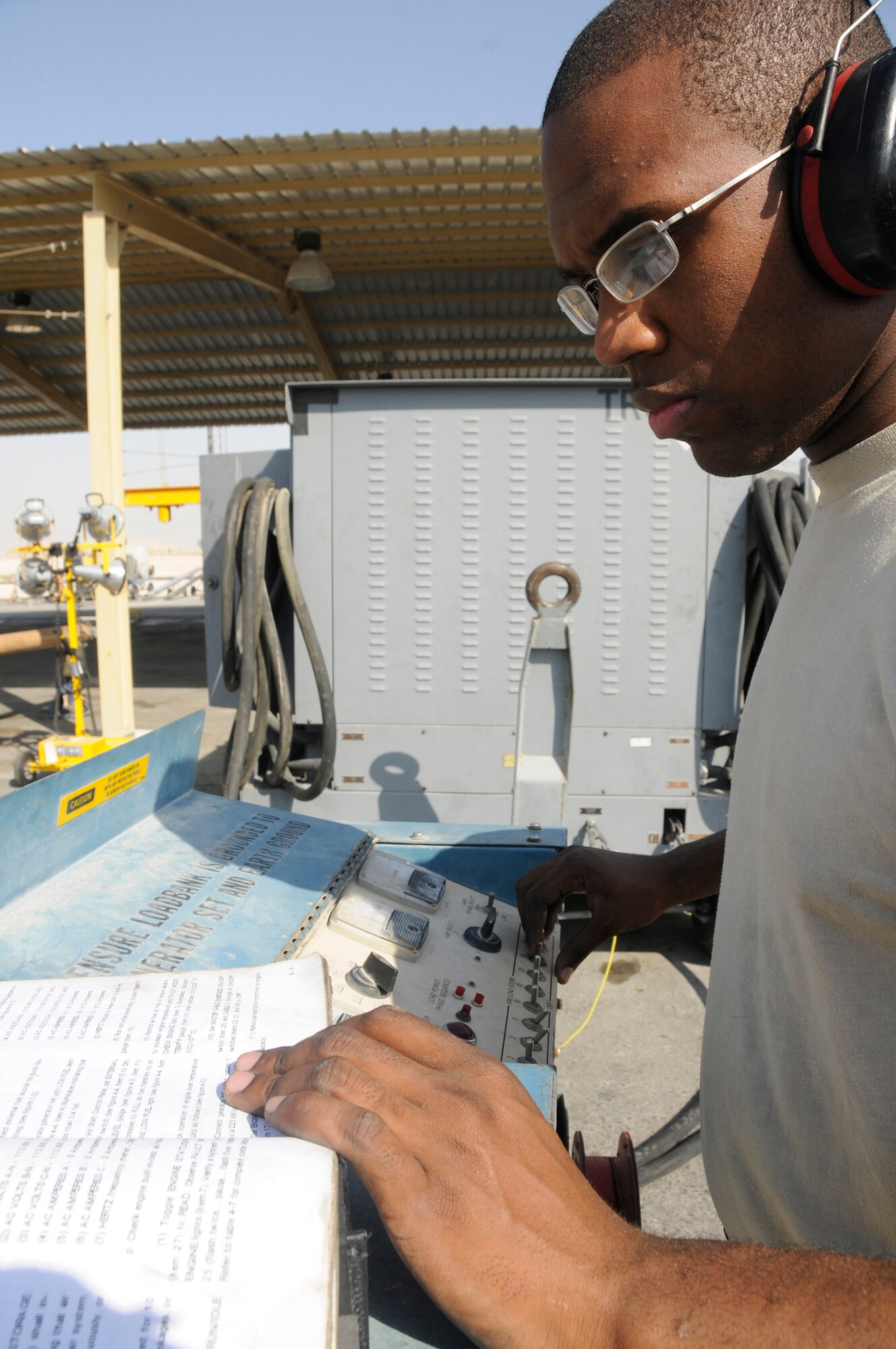 Airman 1st Class Jibri Johnson, aerospace ground equipment mechanic assigned to the 379th Expeditionary Maintenance Squadron, tests a tri-electron generator while reviewing his technical orders Nov. 24, 2008, at an undisclosed air base in Southwest Asia. Testing the tri-electron generator ensures it is giving out the right amount of voltage. Airman Johnson, a native of Graniteville, S.C., is deployed from Grand Forks Air Force Base, N.D., in support of Operations Iraqi and Enduring Freedom and Joint Task Force-Horn of Africa. (U.S. Air Force photo by Staff Sgt. Darnell T. Cannady/Released)