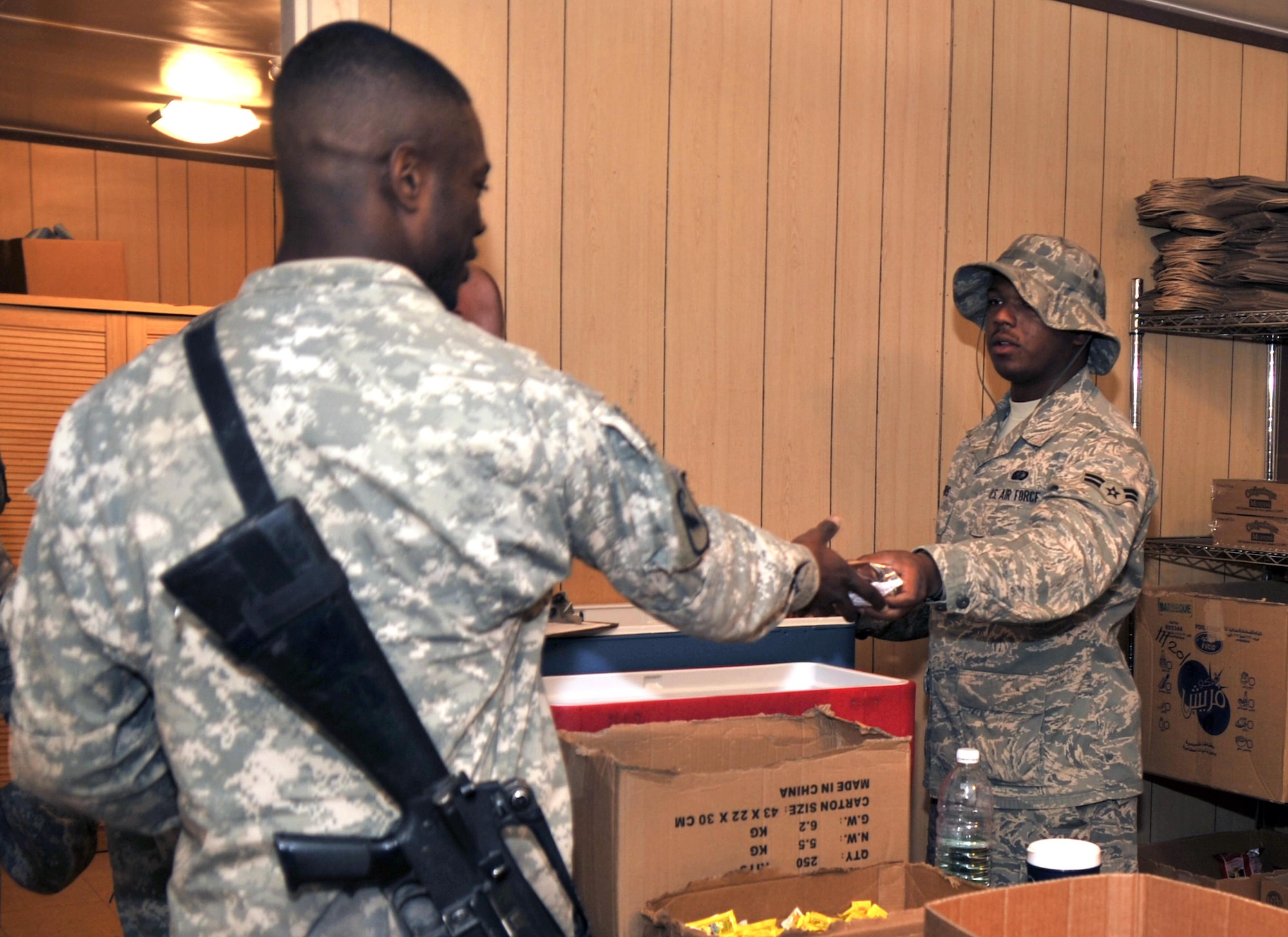 Airman 1st Class Justin Harris serves sanwiches and other snacks to Soldiers awaiting flights at Sather Air Base. Airman Harris is a food services journeyman assigned to the 447th Expeditionary Force Support Squadron and is deployed from the 100th Force Support Squadron, RAF Mildenhall, England. (U.S. Air Force photo by Master Sgt. Brian Davidson)