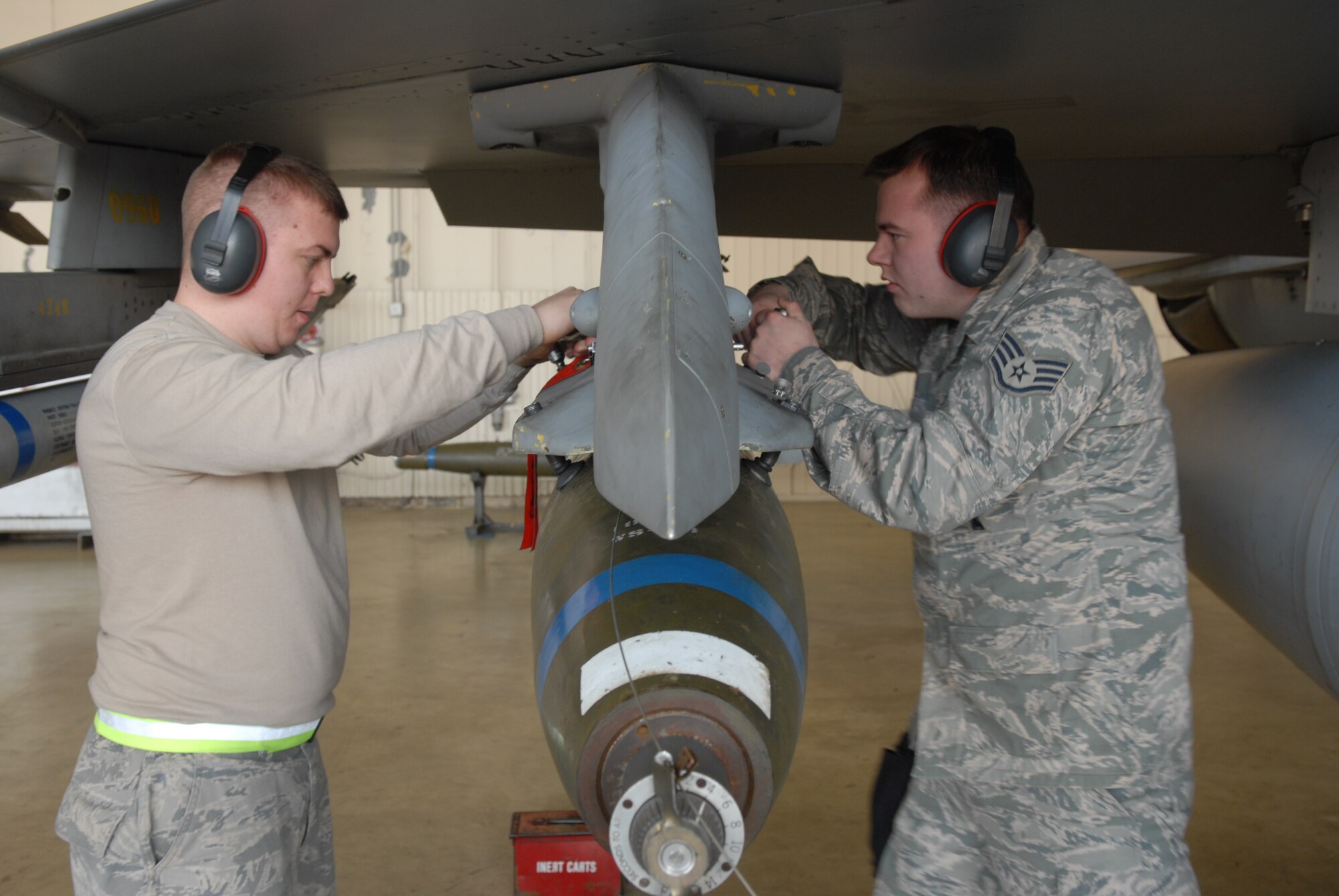 KUNSAN AIR BASE, Republic of Korea --  Senior Airman Shawn Ward and Staff Sgt. Eric Michael, both from the 8th Aircraft Maintenance Squadron, 80th Aircraft Maintenance Unit, load a  weapon to an F-16 during a weapons load crew competition here Dec. 12. The best load crews from the  35th and 80th AMUs compete in the weapon load crew competition every month. US Air Force Photo By: Senior Airman Angela Ruiz)