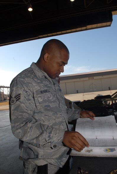 KUNSAN AIR BASE, Republic of Korea --Senior Airman Demetrick Russell, 8th Aircraft Maintenance Squadron, 80th Aircraft Maintenance Unit, reads though a checklist prior to participating in a weapons load crew competition here Dec. 12.  The best load crews from the  35th and 80th AMUs compete in the weapon load crew competition every month. US Air Force Photo By: Senior Airman Angela Ruiz)