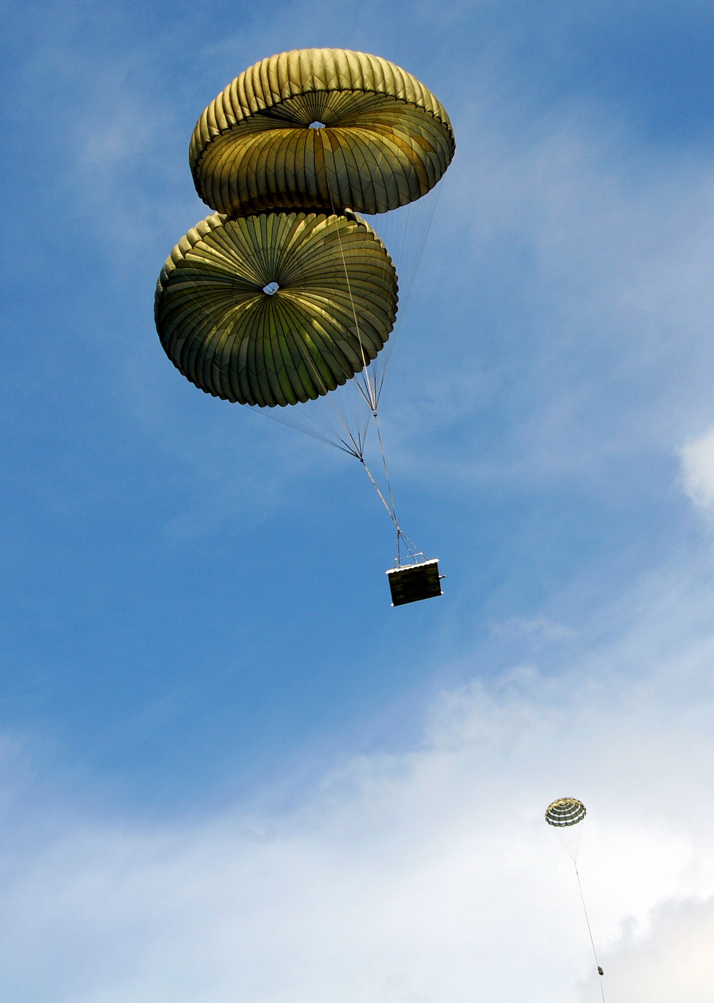 ANDERSEN AIR FORCE BASE, Guam -Pallets glide to the drop zone here Dec. 12, as a practice run was made by two C-130 Hercules in preparation for Operation Christmas Drop. Operation Christmas Drop is a non-profit organization powered by volunteers from Andersen Air Force Base and local Guam community. Each year, the two join forces to aid the people of smaller islands that do not have airstrips or major ports. (U.S. Air Force photo by Airman 1st Class Courtney Witt) 

