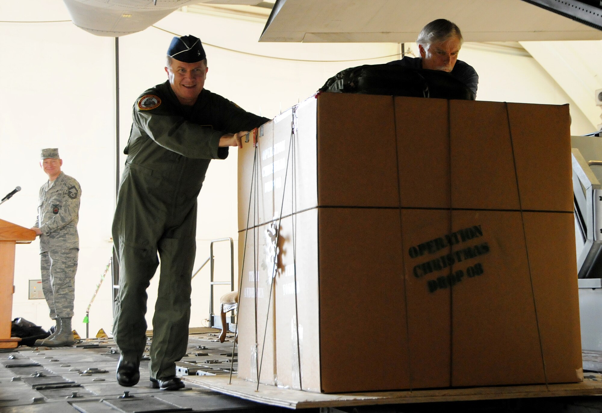 ANDERSEN AIR FORCE BASE, Guam - Brig. Gen. Phil Ruhlman, 36th Wing commander, and Bruce Best, University of Guam Telecommunication and Distance Education Operation station manager, push the first Operation Christmas Drop box filled with supplies into a C-130 Hercules from Yokota Air Base, Japan here Dec 12. Donations from military members and island residents filled more than 180 boxes that will be delivered to over 70 remote islands, making 2008 one of the most successful airdrops in its 56 year history. (U.S. Air Force photo by Airman 1st Class Courtney Witt)