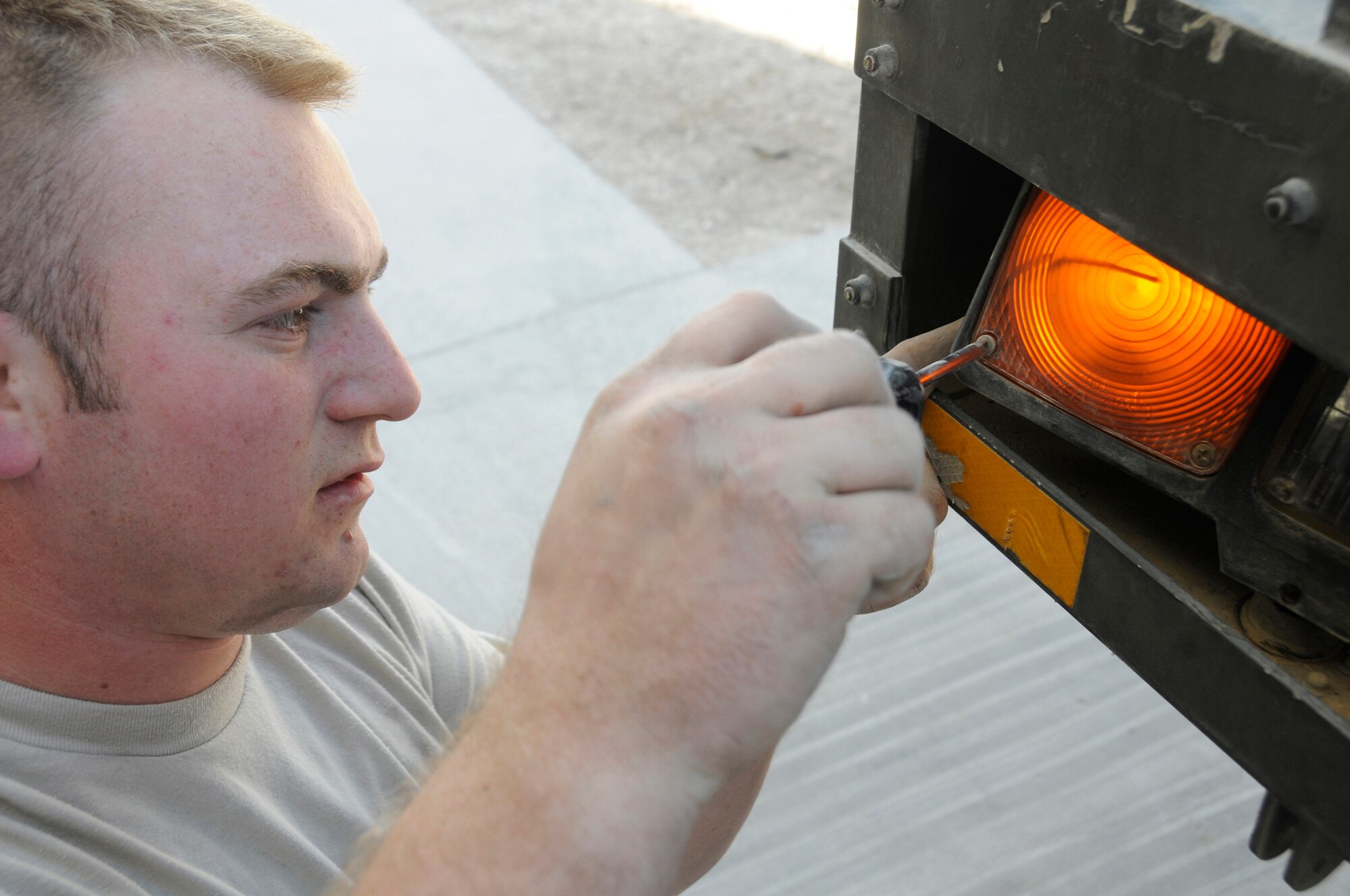 Senior Airman Michael Poole, vehicle maintenance journeyman assigned to the 379th Expeditionary Logistics Readiness Squadron, uses a screwdriver to remove a headlight assembly on a 60K loader Dec. 11, at an undisclosed air base in Southwest Asia.  Airman Poole, a native of Little Rock, Ark., is deployed from Elmendorf Air Force Base, Alaska, in support of Operations Iraqi and Enduring Freedom and Joint Task Force-Horn of Africa. (U.S. Air Force photo by Staff Sgt. Darnell T. Cannady/Released)