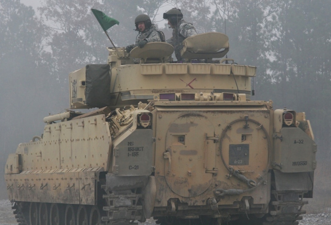 Army Capt. Michael Riley, commander of Company C, 1-185th Combined Arms Battalion, and Army Brig. Gen. Keith Jones, assistant deputy adjutant general for California’s Army National Guard, get front-row action as they observe a M2 Bradley fighting vehicle live-fire exercise at Camp Shelby, Miss. The exercise is part of training to ready the 1-185th CAB for a deployment to Kosovo. U.S. Army photo