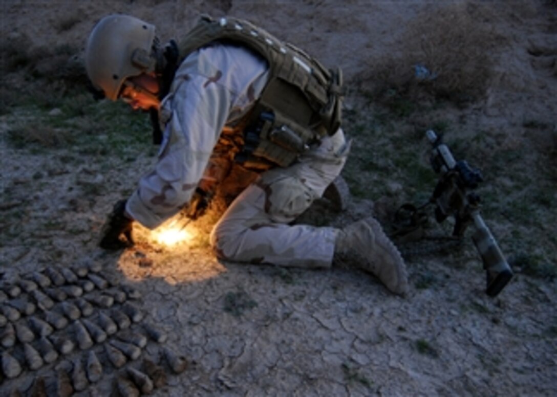 U.S. Navy Petty Officer 1st Class Aaron Ritter, with Explosive Ordnance Disposal Mobile Unit 1, uncovers buried projectile fuses in Tikrit, Iraq, on Dec. 5, 2008.  