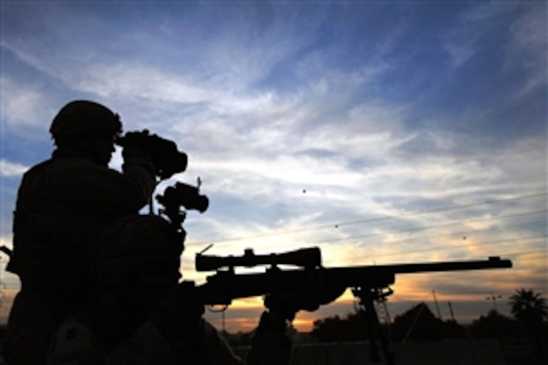 A U.S. Air Force sharpshooter scans the surrounding area through his rifle scope while a videographer documents the action in the Doura community of southern Baghdad, Iraq, Dec. 7, 2008. The airmen are assigned to Detachment 3, 732 Expeditionary Security Forces Squadron, 1st Brigade Combat Team.