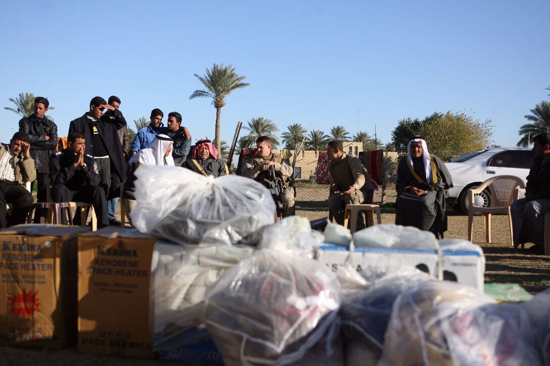 Gifts brought by Marines of Company E, 2nd Battalion, 9th Marine Regiment, Regimental Combat Team 1, are presented to the family of slain Iraqi Policeman Capt. Ali Rezaij at the family’s home in Jazeera, Iraq, Dec. 11. The Marines brought heaters, generators and blankets to help them through the winter.