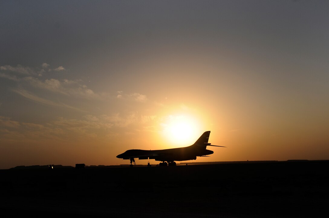 The setting sun silhouettes a B-1B Lancer, Dec. 12, at an undisclosed air base in Southwest Asia.  Carrying the largest payload of both guided and unguided weapons in the Air Force inventory, the multi-mission B-1 is the backbone of America's long-range bomber force. It can rapidly deliver massive quantities of precision and non-precision weapons against any adversary, anywhere in the Central Command area of responsibility.  (U.S. Air Force photo by Tech. Sgt. Michael Boquette/Released)