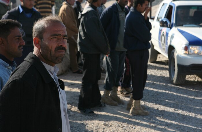 Sons of Iraq members wait patiently at Outpost Delta to receive their monthly paychecks from Task Force 1st Battalion, 3rd Marine Regiment, Regimental Combat Team 1, Dec. 13. Nearing the end of Coalition funded paychecks, a concluding effort to register all SOI was completed this month, ensuring SOI in the Greater Karmah Region continue their employment.