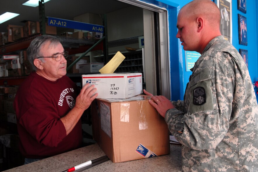 Mel Hagen, an Air Force retiree currently working for the University of Pheonix on Kadena Air Base, assists Army Specialist Paul Murray in getting his package at the Kadena Post Office Dec. 12, 2008.
Members of Team Kadena volunteer at the Post Office to help with the large influx of mail during the holiday season.
(U.S. Air Force photo/Staff Sgt. Angelique Perez)